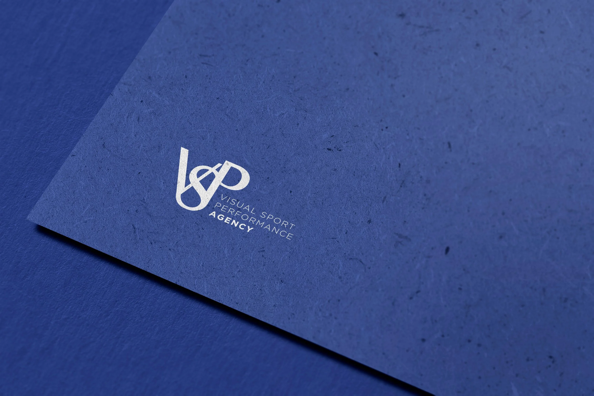 Papier bleu foncé avec un logo blanc représentant une combinaison de symboles, accompagné du texte 'Visual Sport Performance Agency'.