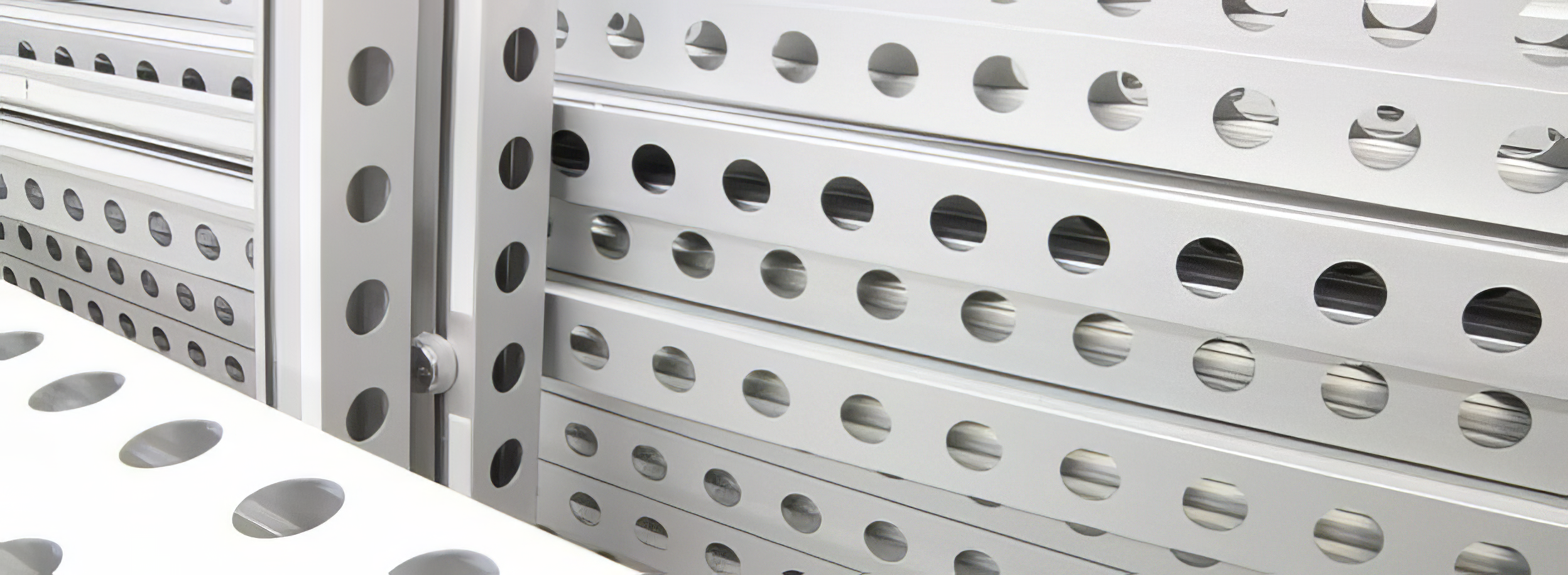 Close-up of a metallic perforated metal grid and bracket with circular holes known as beMatrix Frames.