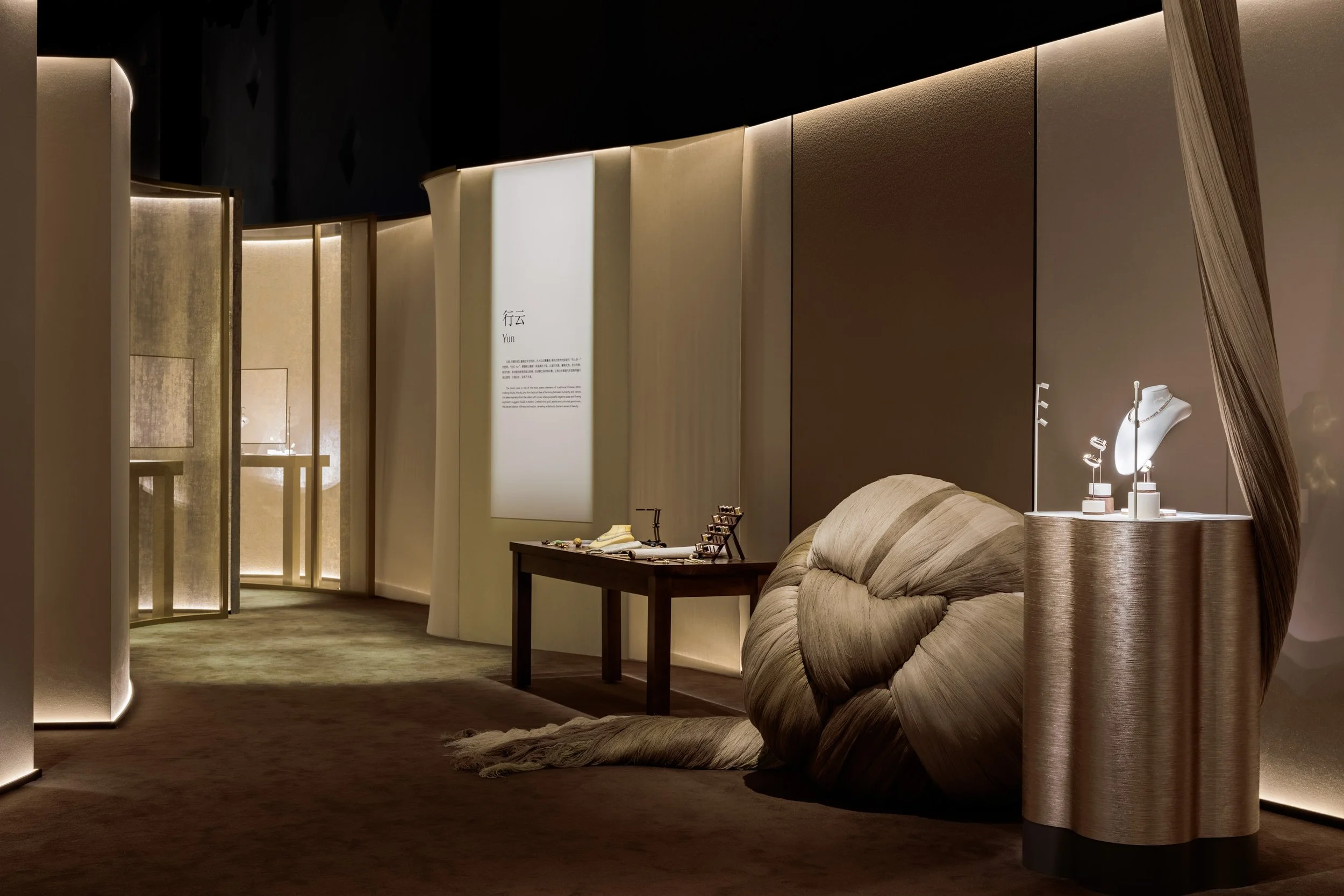 Interior of a jewelry store with a display table, a display bust with jewelry, and soft lighting highlighting the furniture and decor.