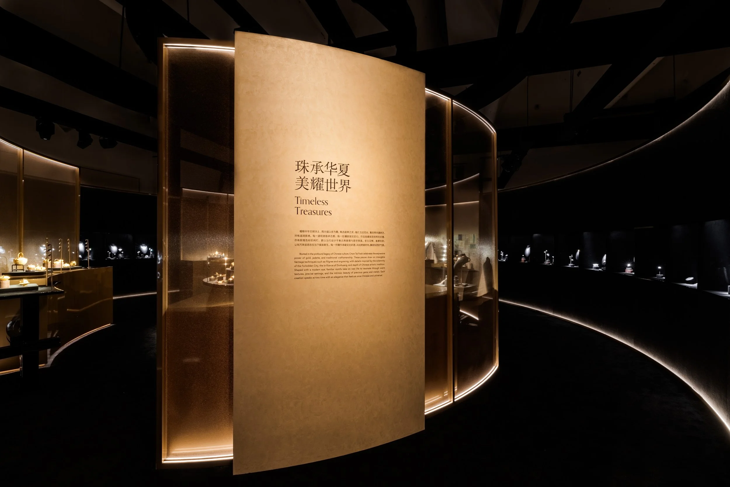 A display area featuring jewelry and a large beige panel with Chinese characters and the English translation 'Timeless Treasures' in a dark, modern setting with illuminated accents.