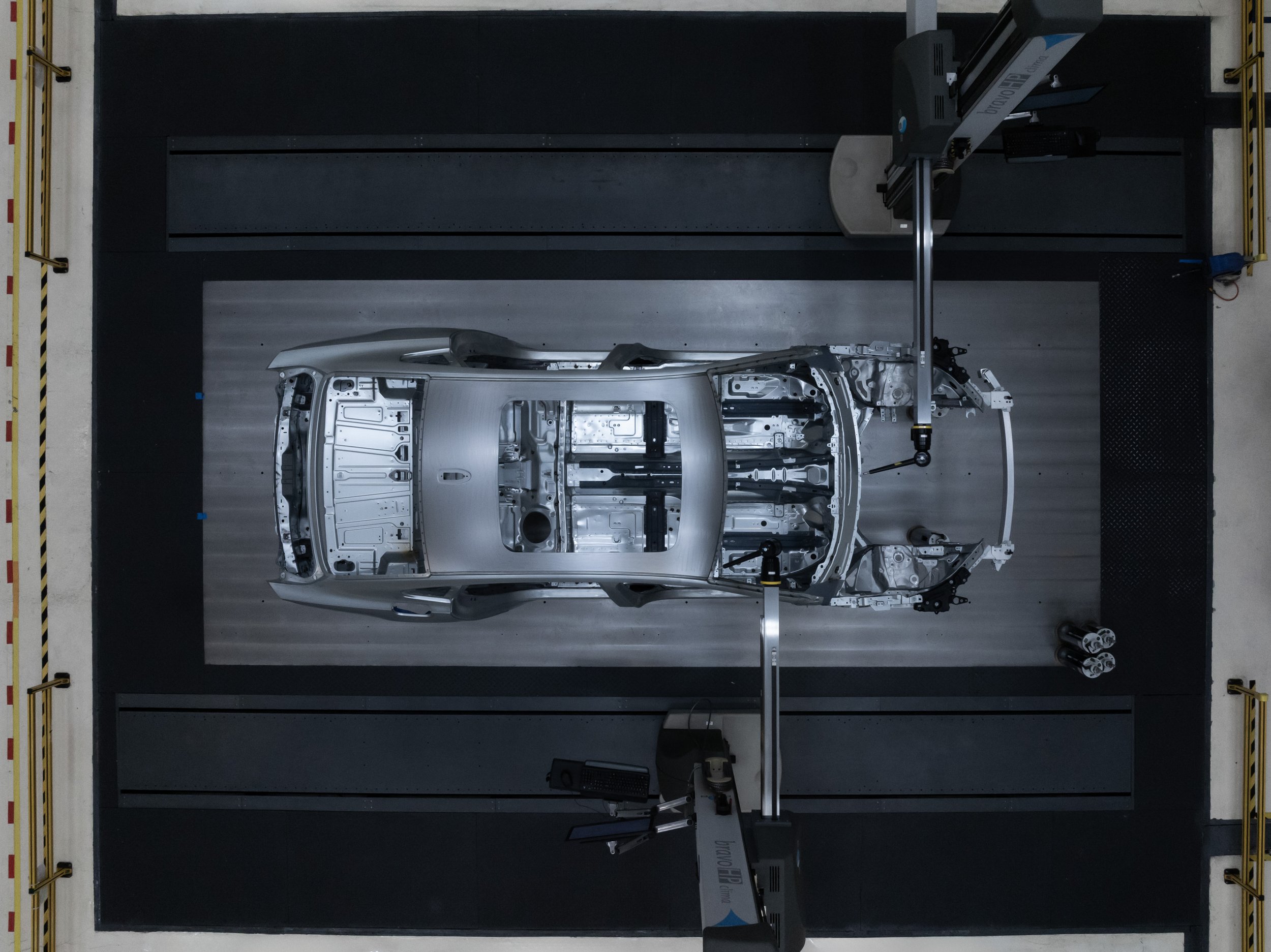 An automotive manufacturing robot arm working on a car frame in a factory