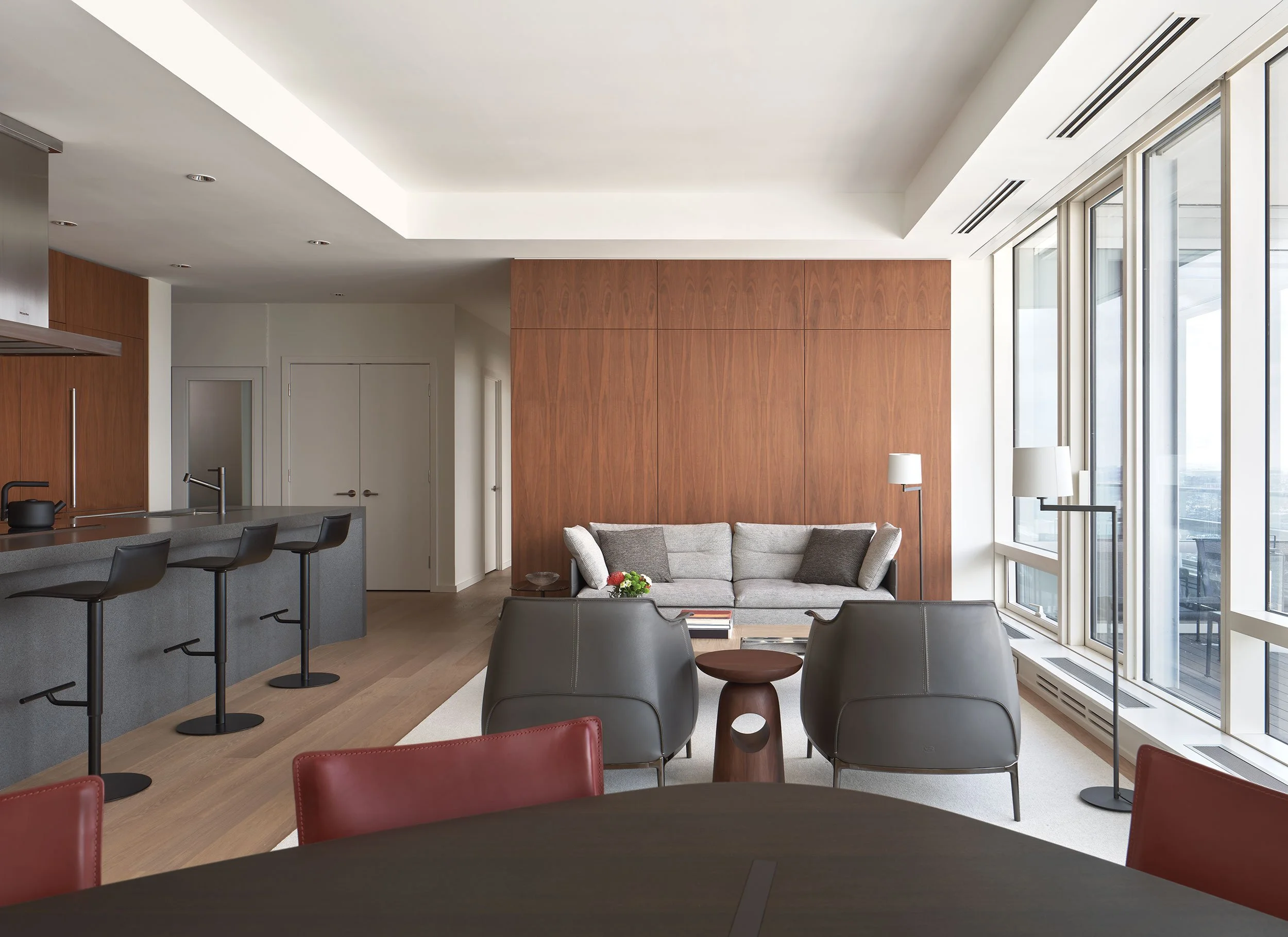 Shangri-la Residence living room with wood clad wall and modern kitchen island