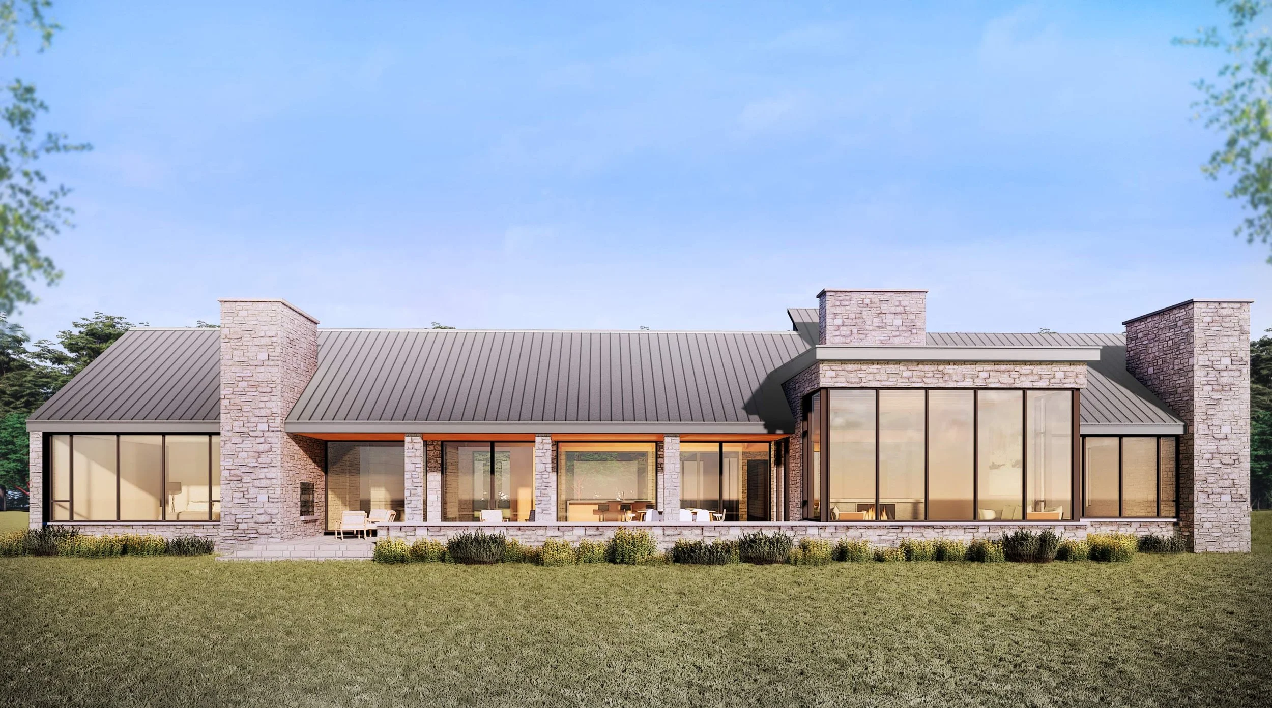 Modern single-story house with large glass windows, stone accents, and a metal roof, set on a grassy lawn with trees in the background.