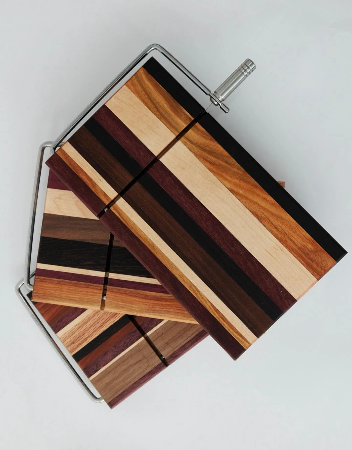 I&rsquo;ve been working on some really cute cheese cutting boards!  They&rsquo;re small enough to fit a block of cheese and you use the wire handle to slice.  The boards pictured feature maple, oak, purple heart, wedge and walnut.  Photo by @concord.