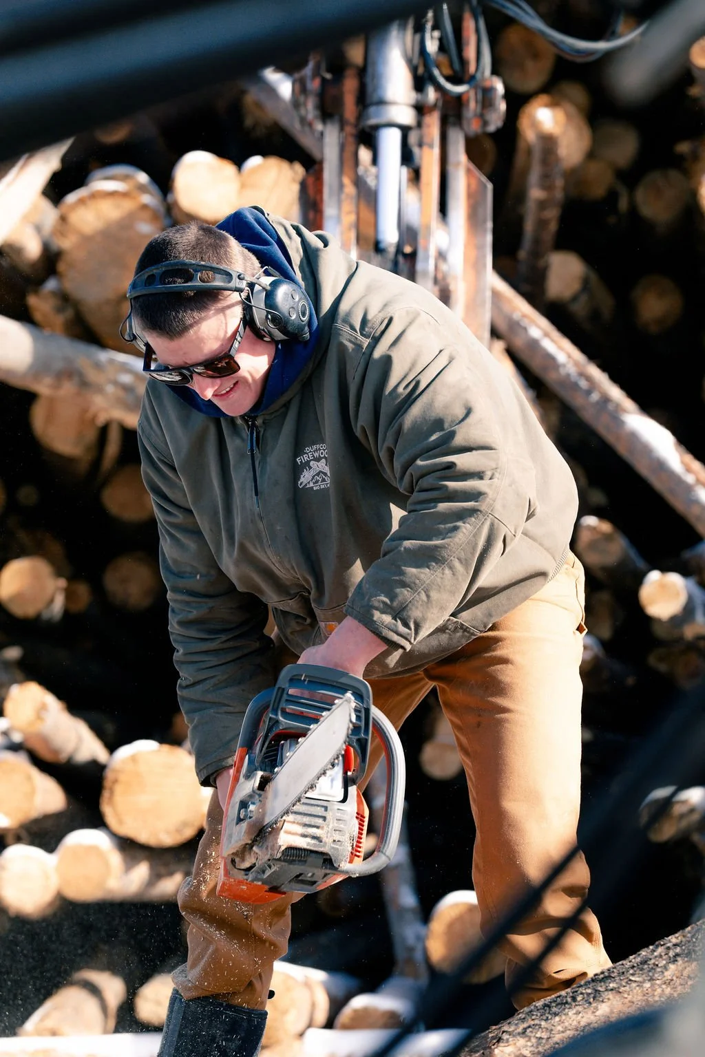 Duffco Firewood founder, Matt Duffy, in action with lumber and a chainsaw.