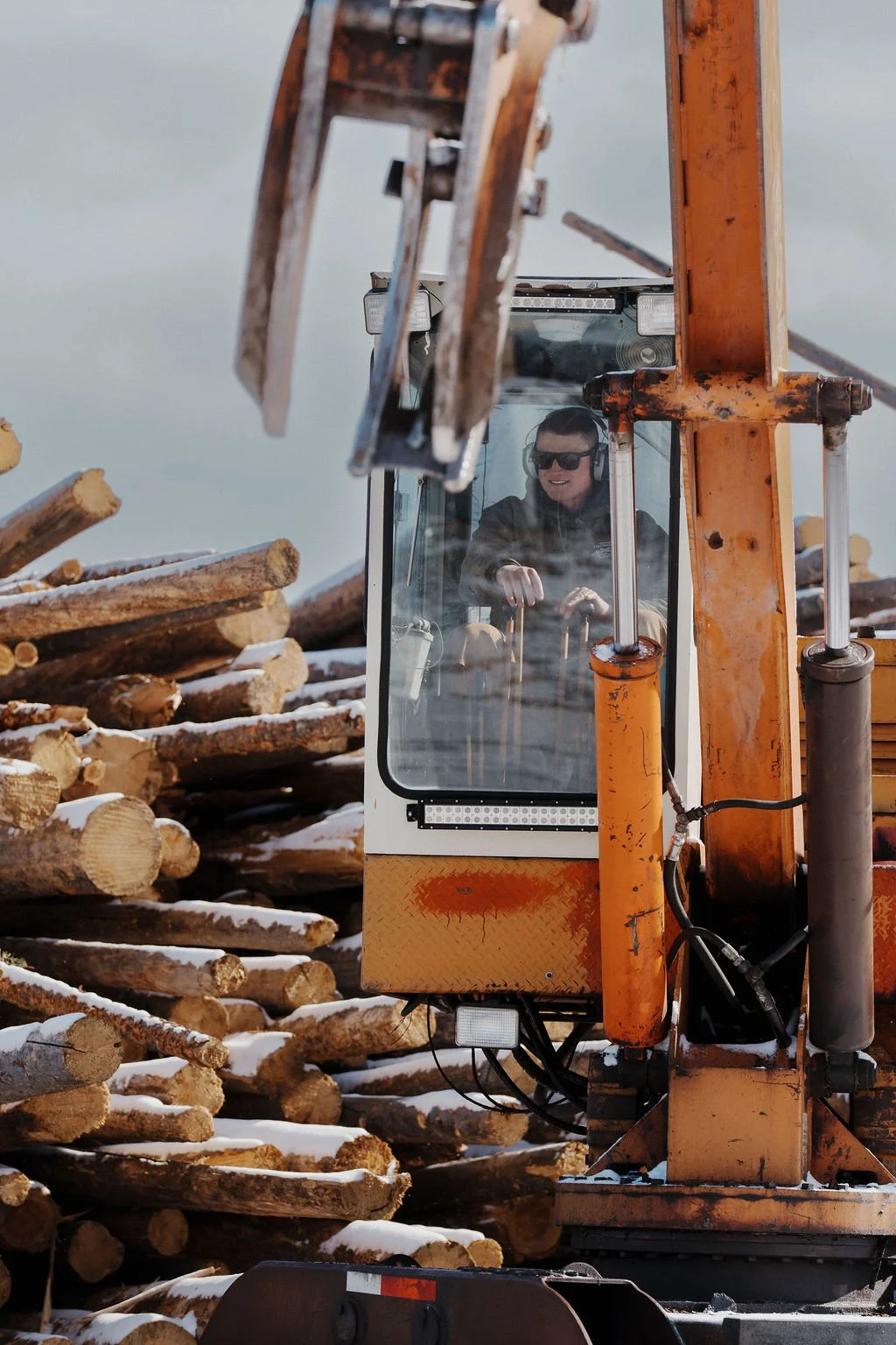 Duffco Firewood founder, Matt Duffy, using a grapple arm to found wood around.