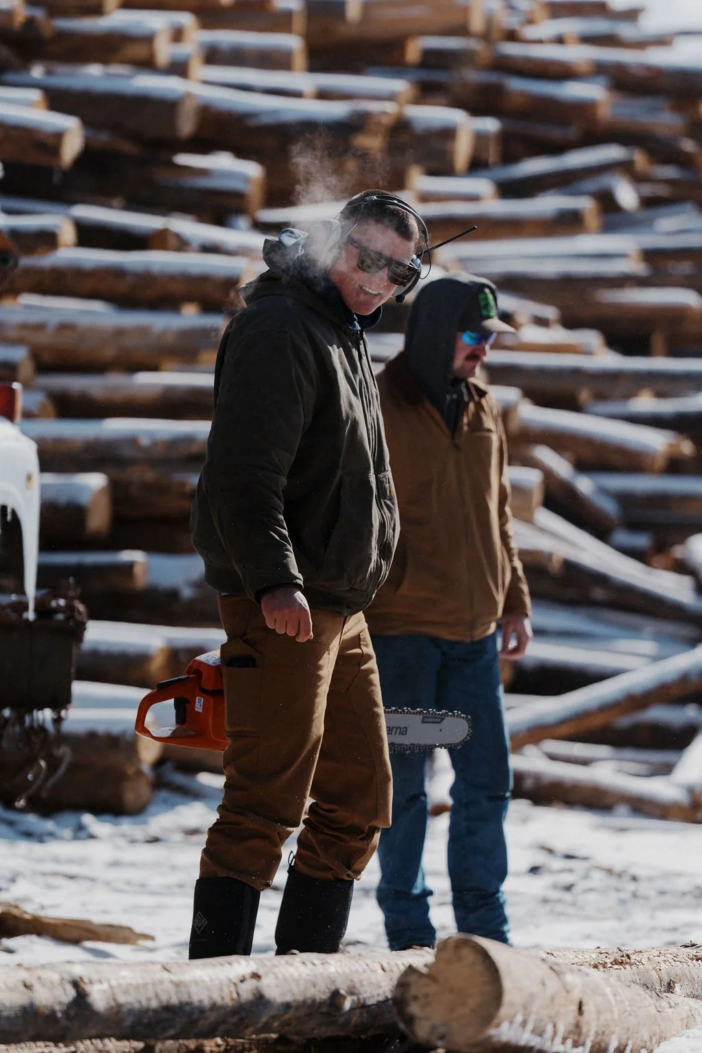 Duffco Firewood founder, Matt Duffy, and a  employee standing in the lumber yard.