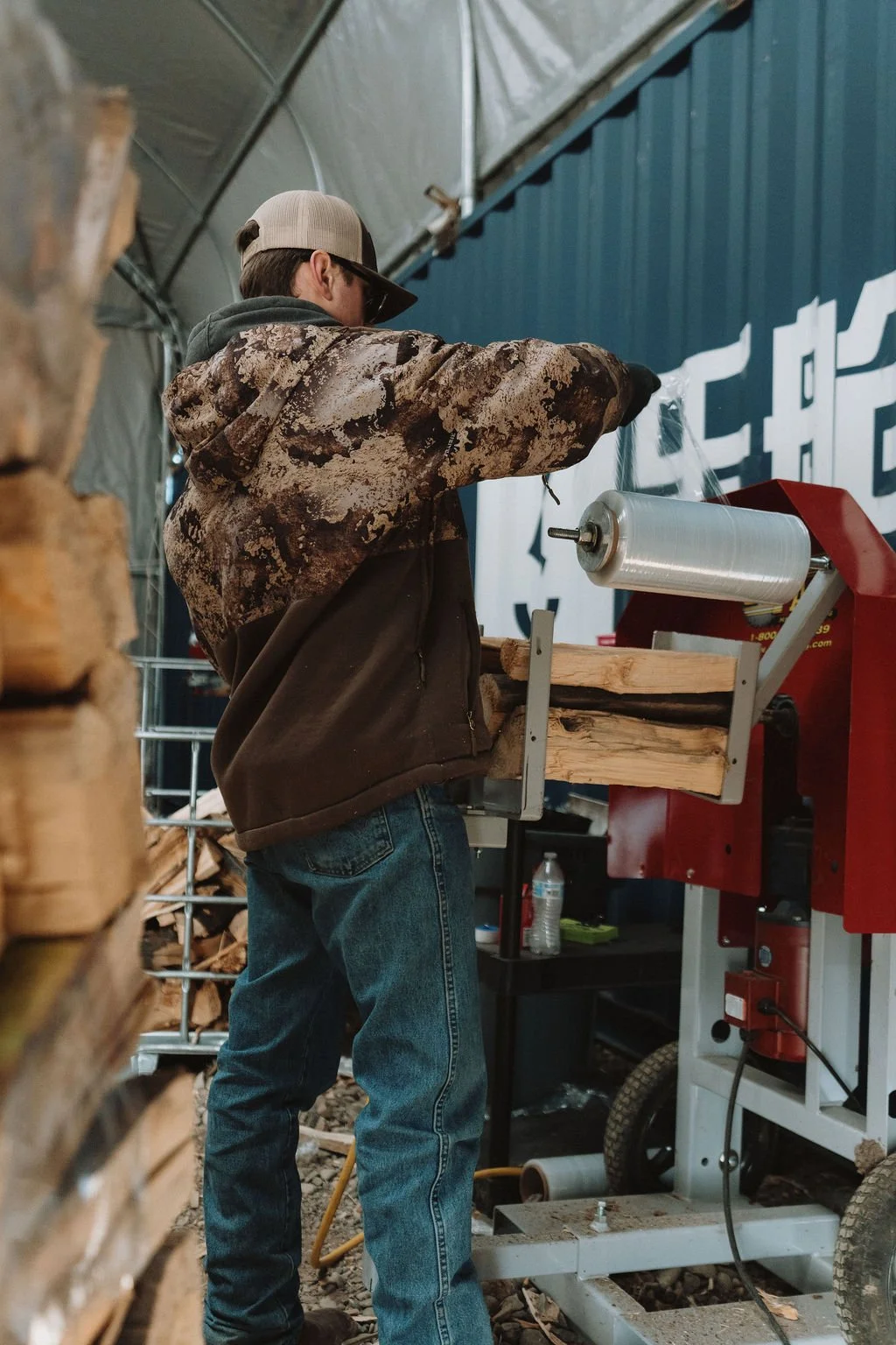 Duffco Firewood employee using machinery to wrap firewood bundles.