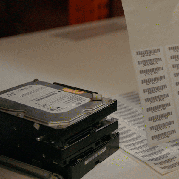 Employee crushing hard drives for secure data destruction at a Long Island, New York document management and storage company.