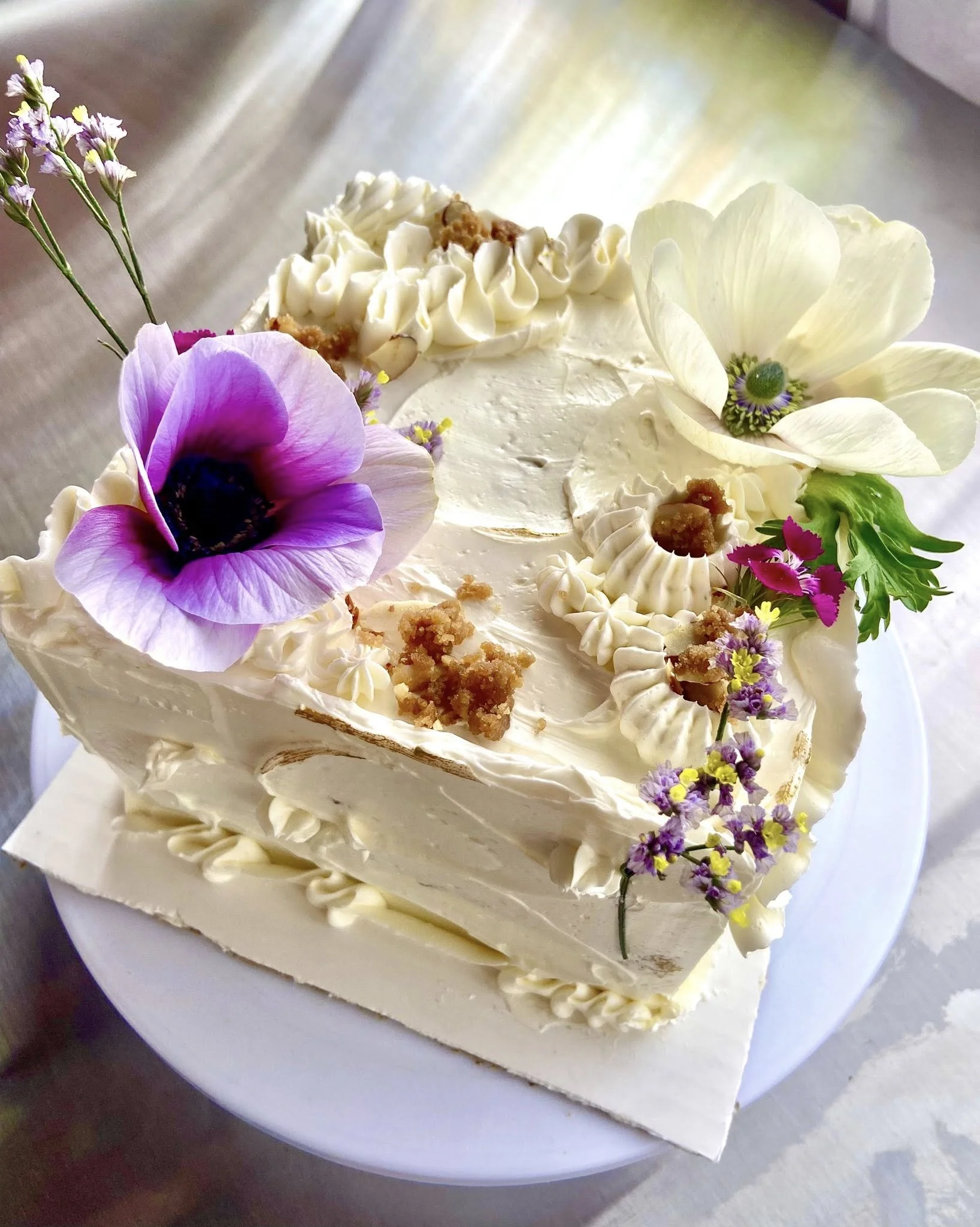 Decorative white cake with flowers and cream