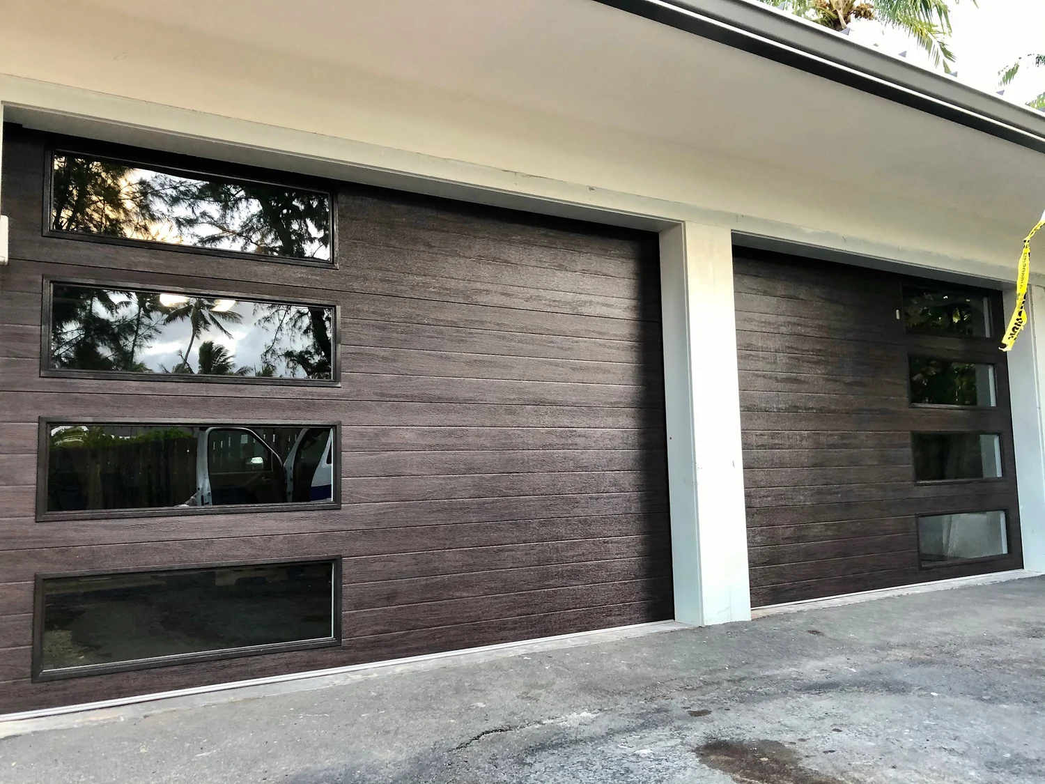 Modern wood-look garage door with glass windows installed on a St. George, Utah home
