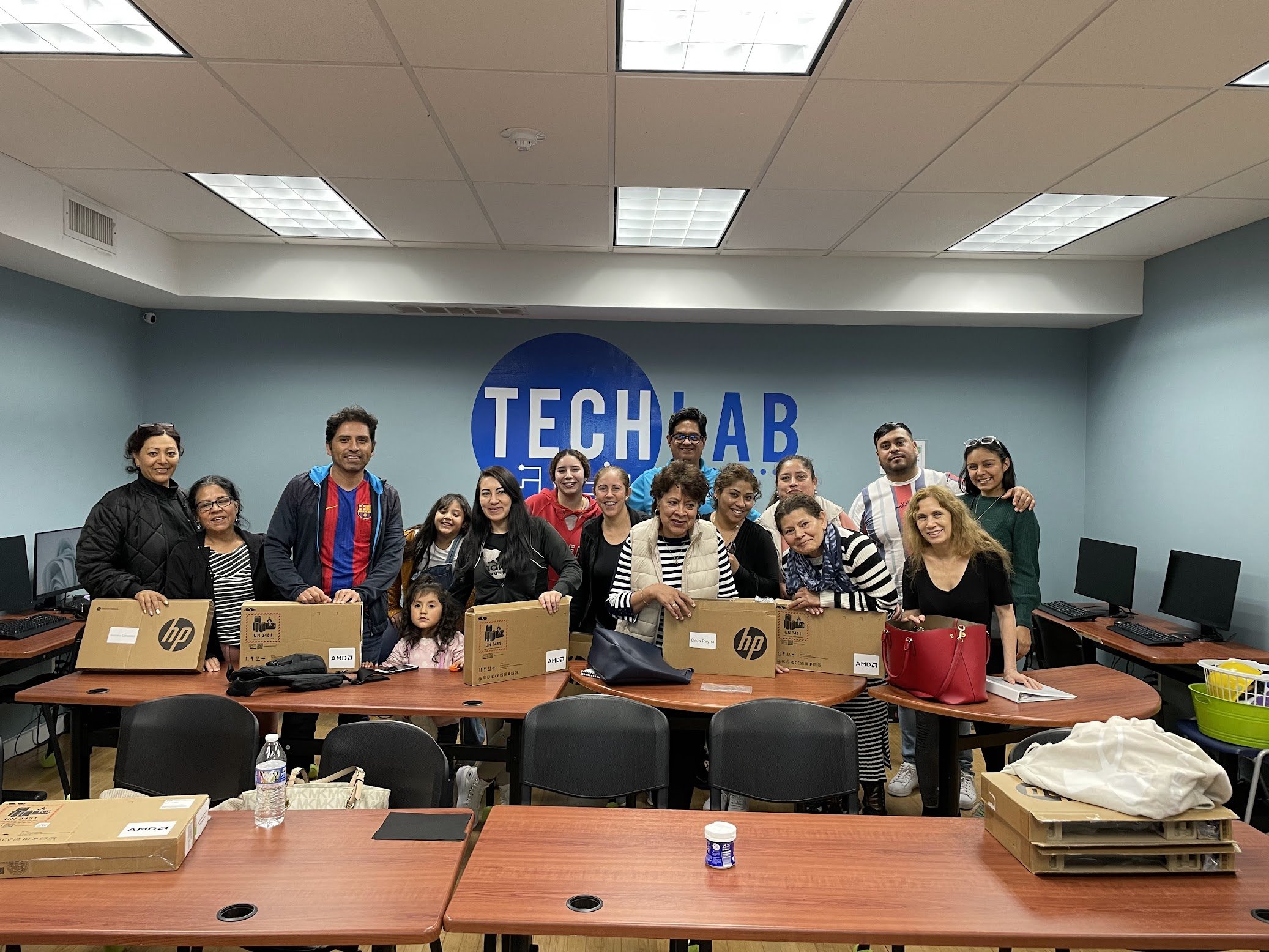 A group of learners graduating with new laptops.