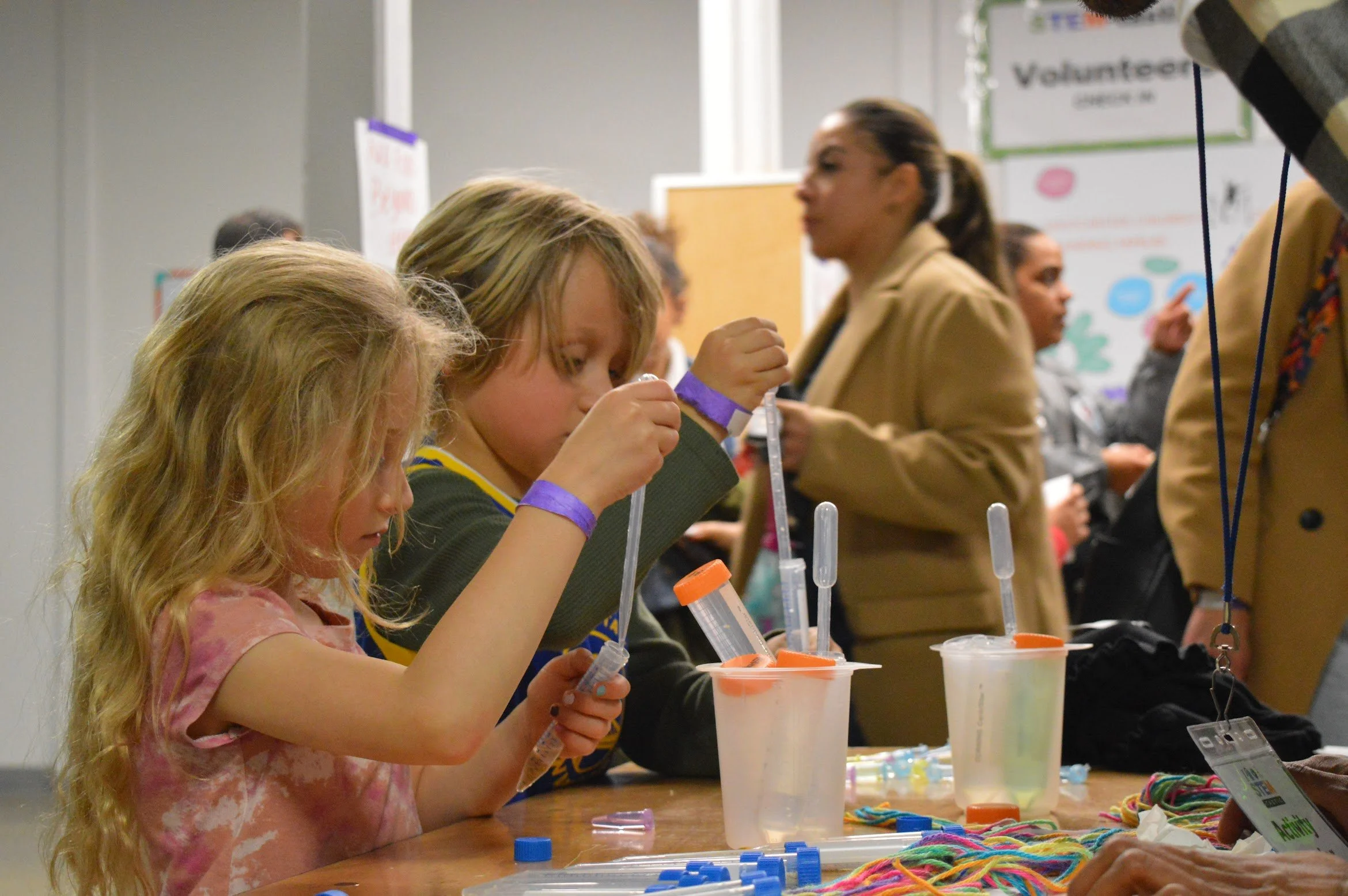Two kids using pipettes to learn chemistry at an after-school program