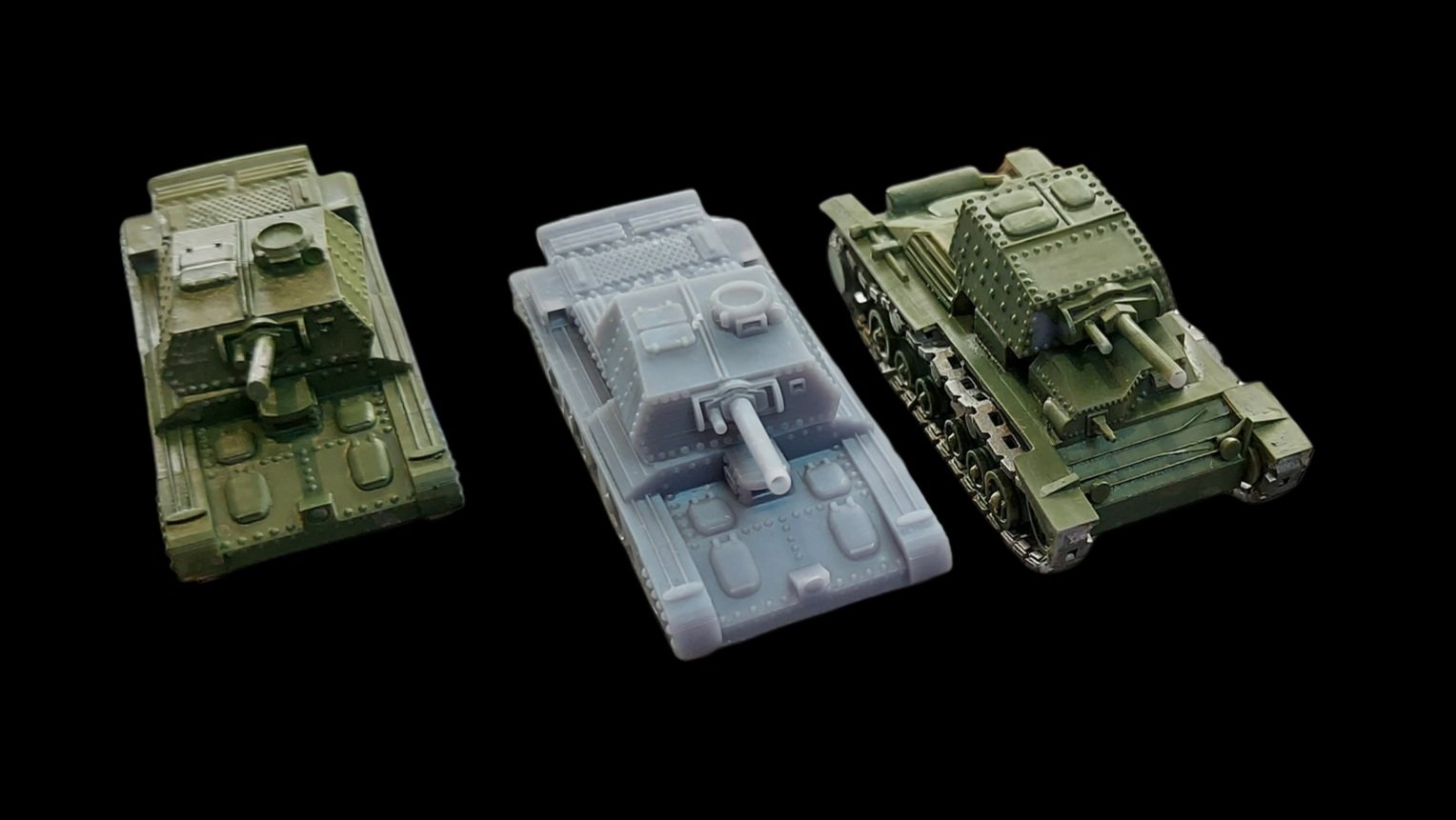 Three toy model tanks on a black background, in green, gray, and darker green colors.