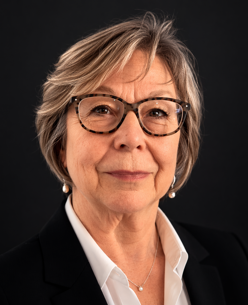 Carol Simon, secretary of board, she has short gray hair, wearing glasses, earrings, and a patterned blouse, against a light green background.