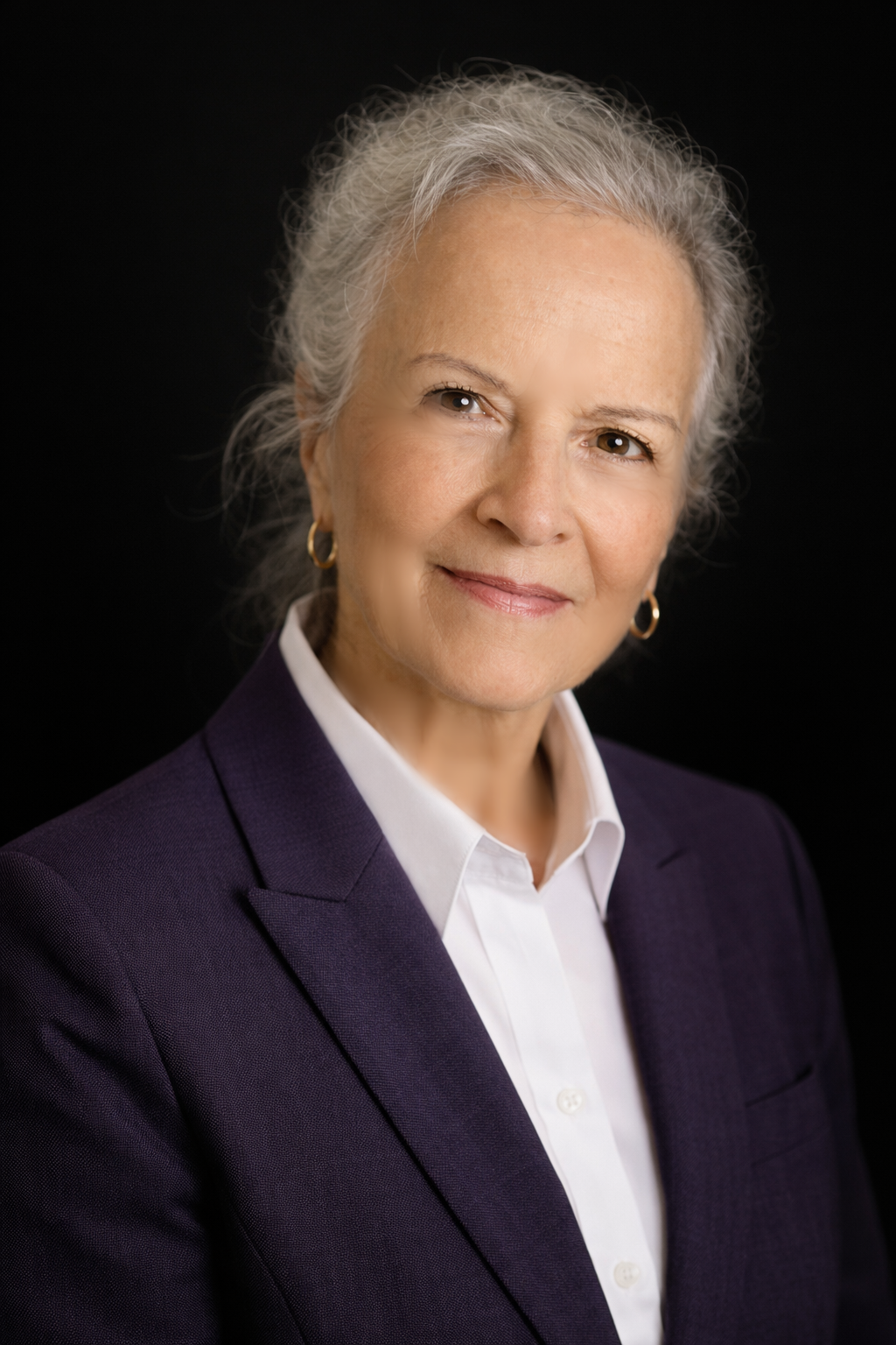 Francine Quenneville, Francophone representative and director, who is a smiling elderly woman with short gray hair, wearing a blue jacket, sitting on a dark couch.