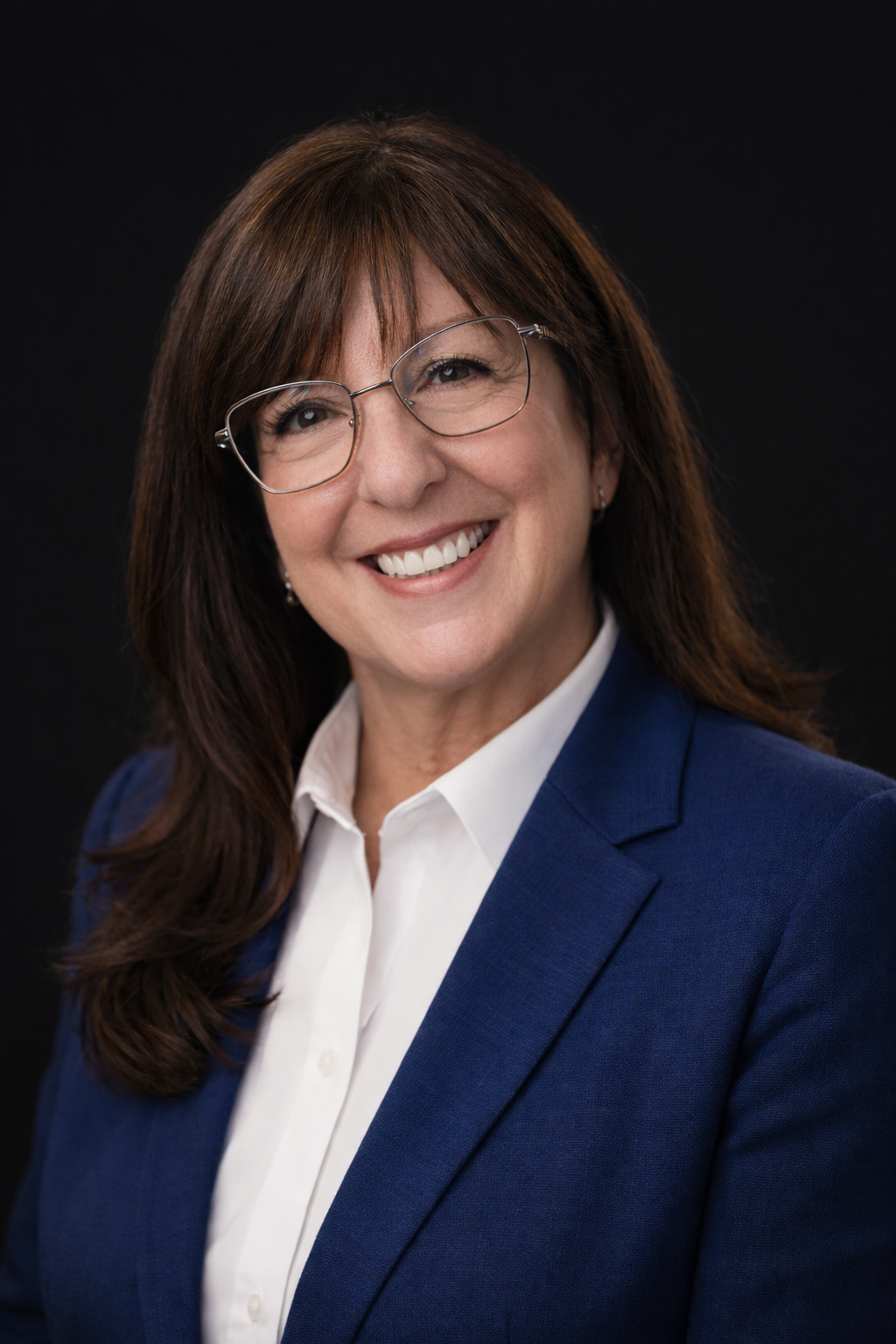 Rachelle Beaubien, the chair of the board, she is smiling with glasses and brown hair standing next to a tree with a pink jacket tied around her waist.