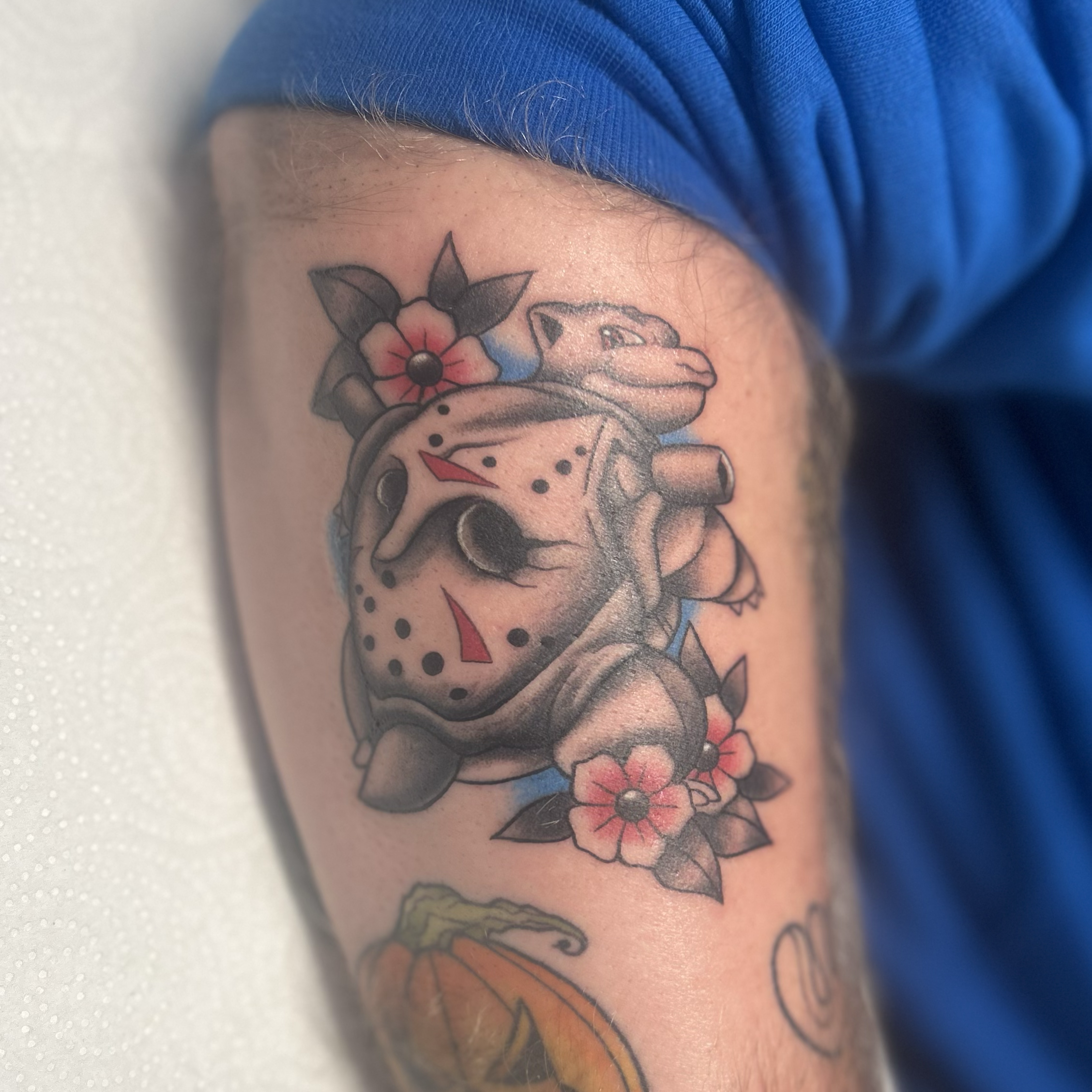 Neo‑traditional Blastoise Pokémon tattoo with Jason mask shell and blue-red color pops