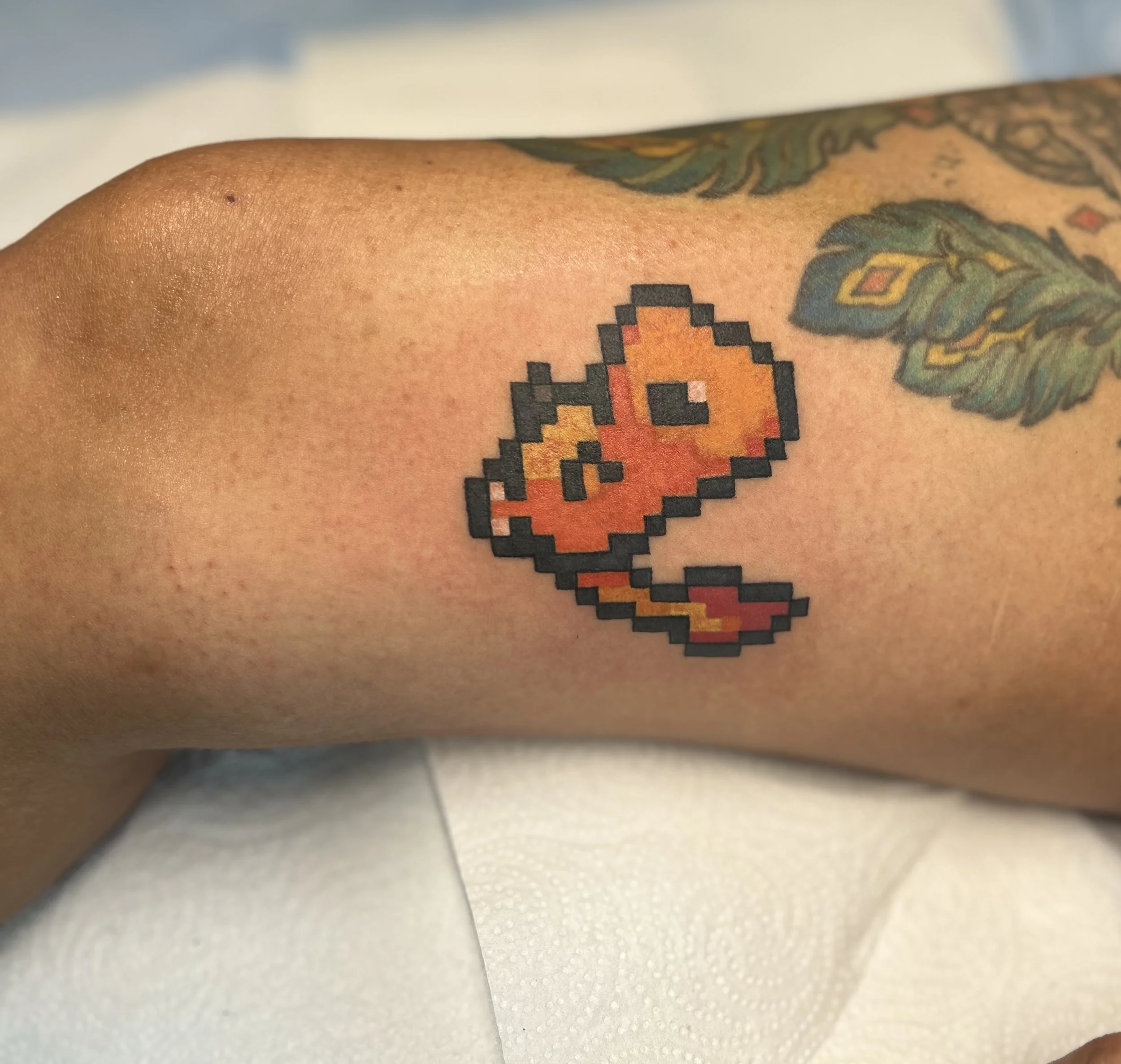Full‑color pixel art Charmander Pokémon tattoo, clean retro video game design