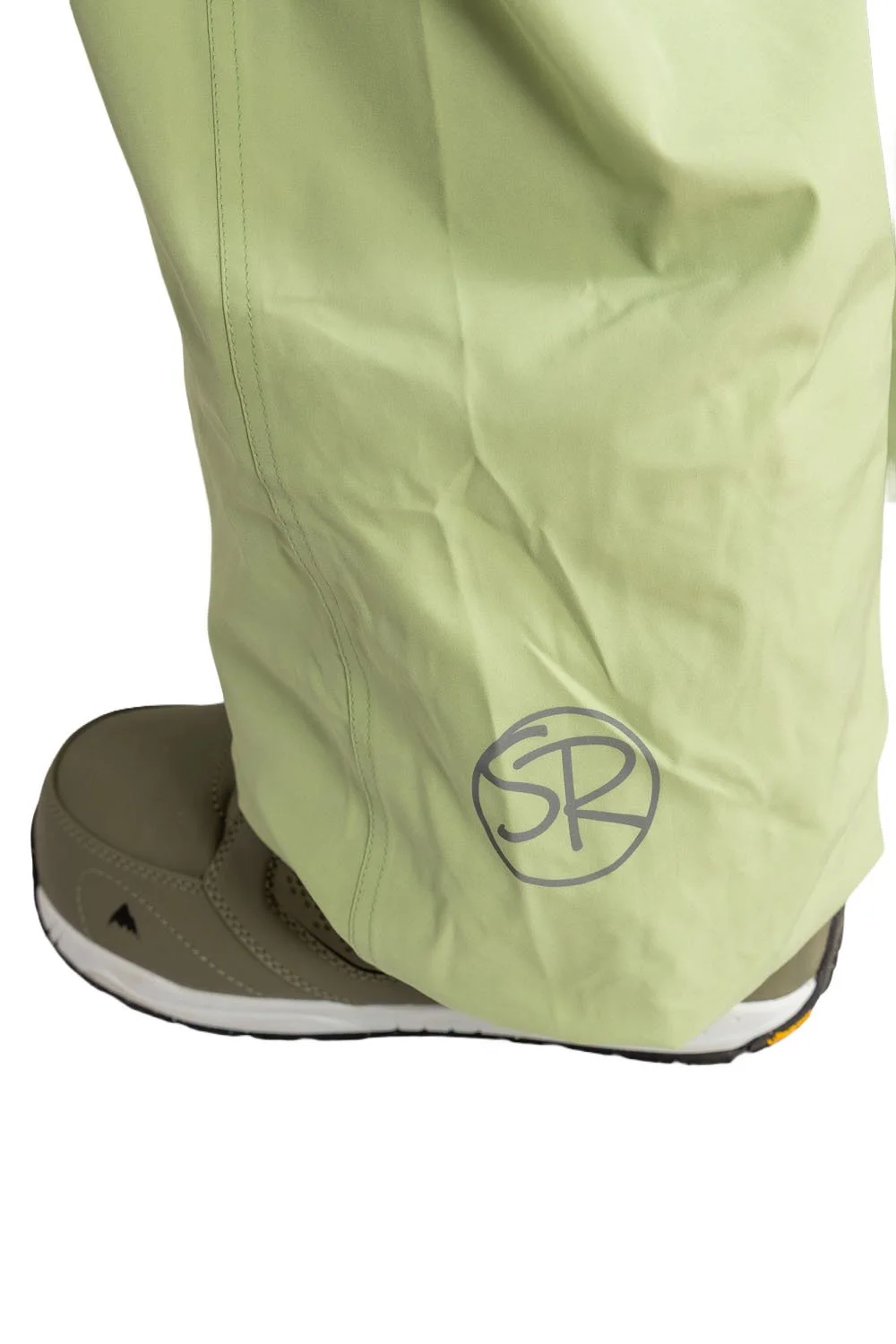 Close-up of Snowripper logo near left ankle on Mist Green Drift Pants.