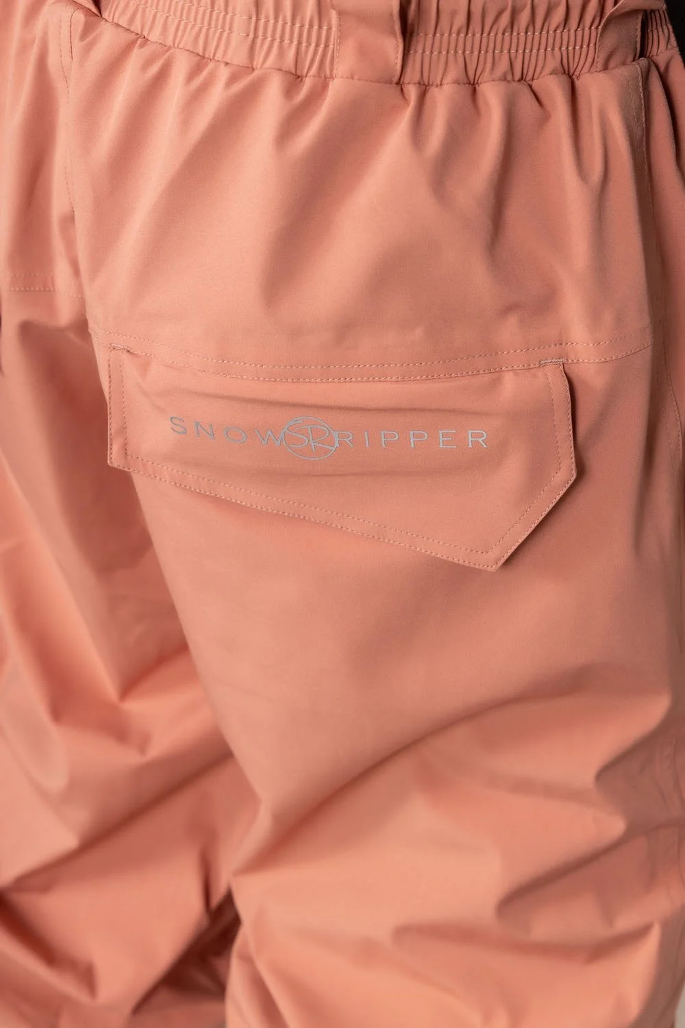 Close-up of Snowripper logo on back pocket of Coral Beacon Drift Pants.