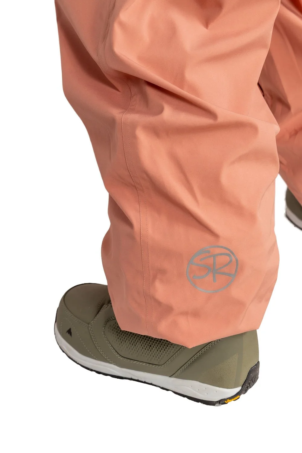Close-up of Snowripper logo near left ankle on Coral Beacon Drift Pants.