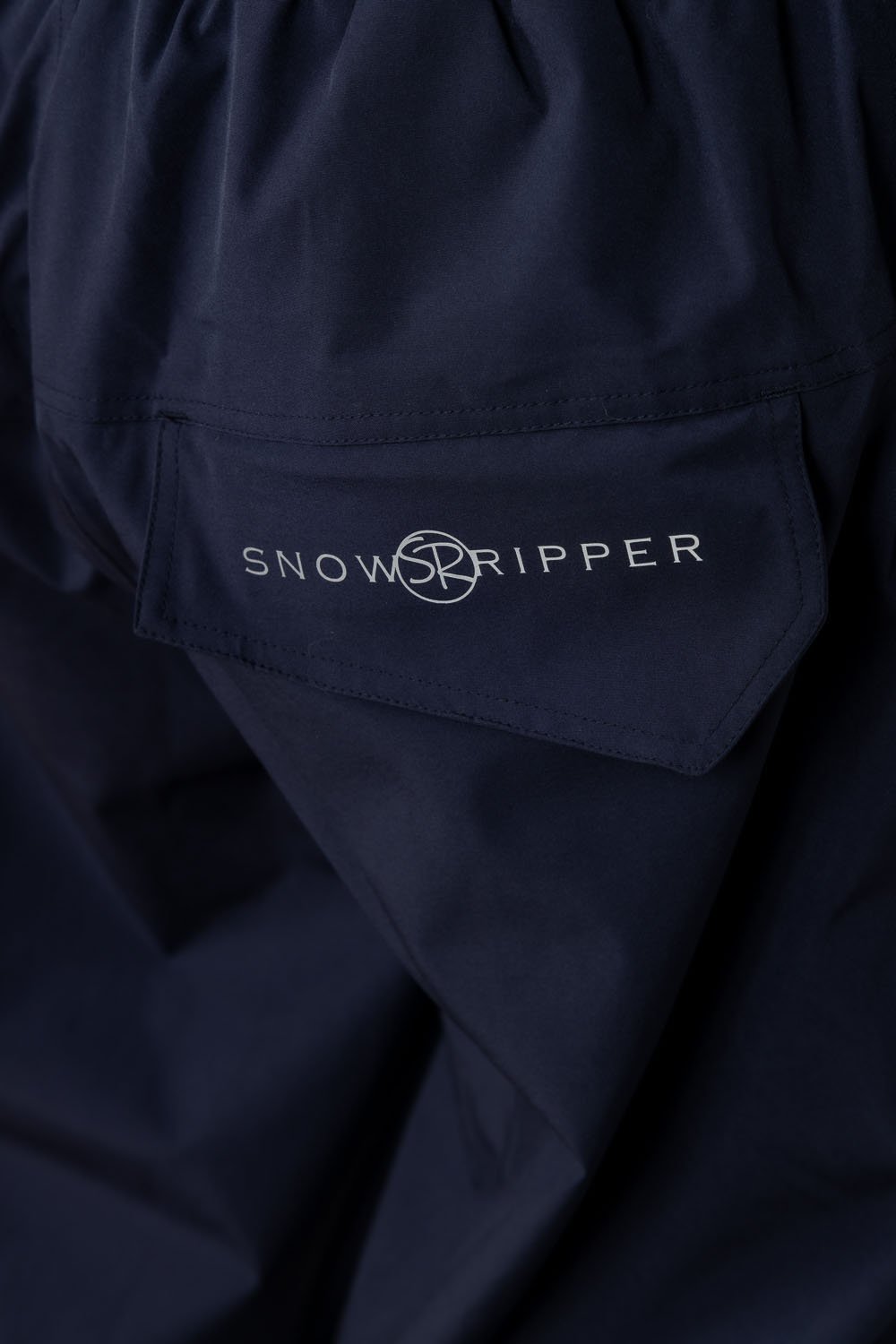 Close-up of Snowripper logo on back pocket of Crown Blue Drift Pants.