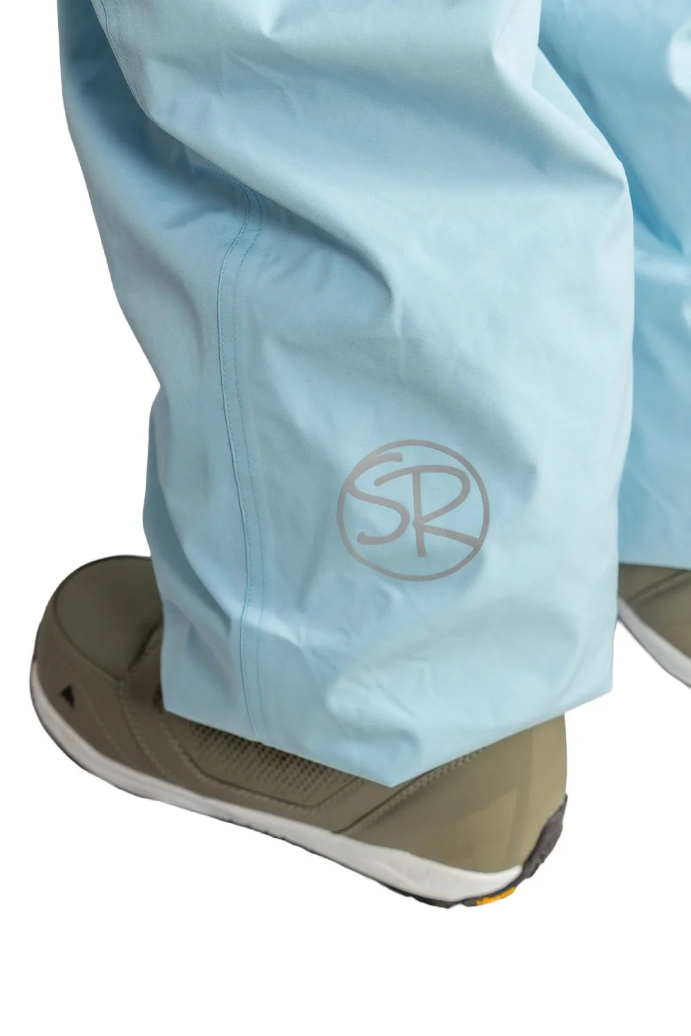Close-up of Snowripper logo near left ankle on Ballad Blue Drift Pants.