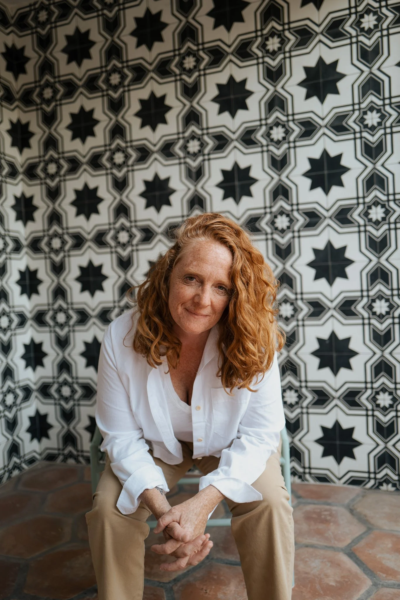 Malaurie Hotier seated against a patterned tile wall