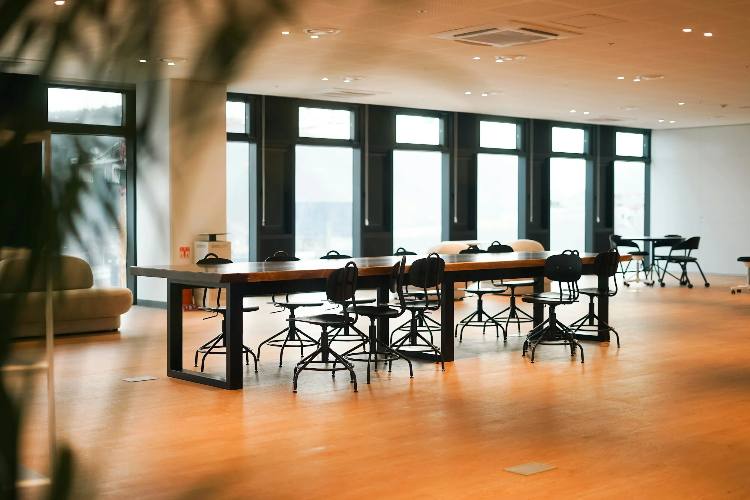 Empty conference room with a long wooden table and black chairs, for a meeting that will discuss the intercultural development inventory assessment or the ability to shift cultural perspective and adapt behaviour effectively
