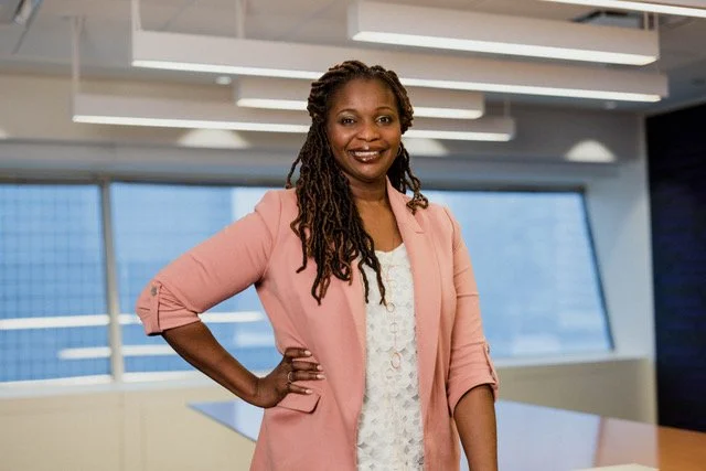 Ogho Ikalo our DEI partner and facilitator posing in a pink blazer.