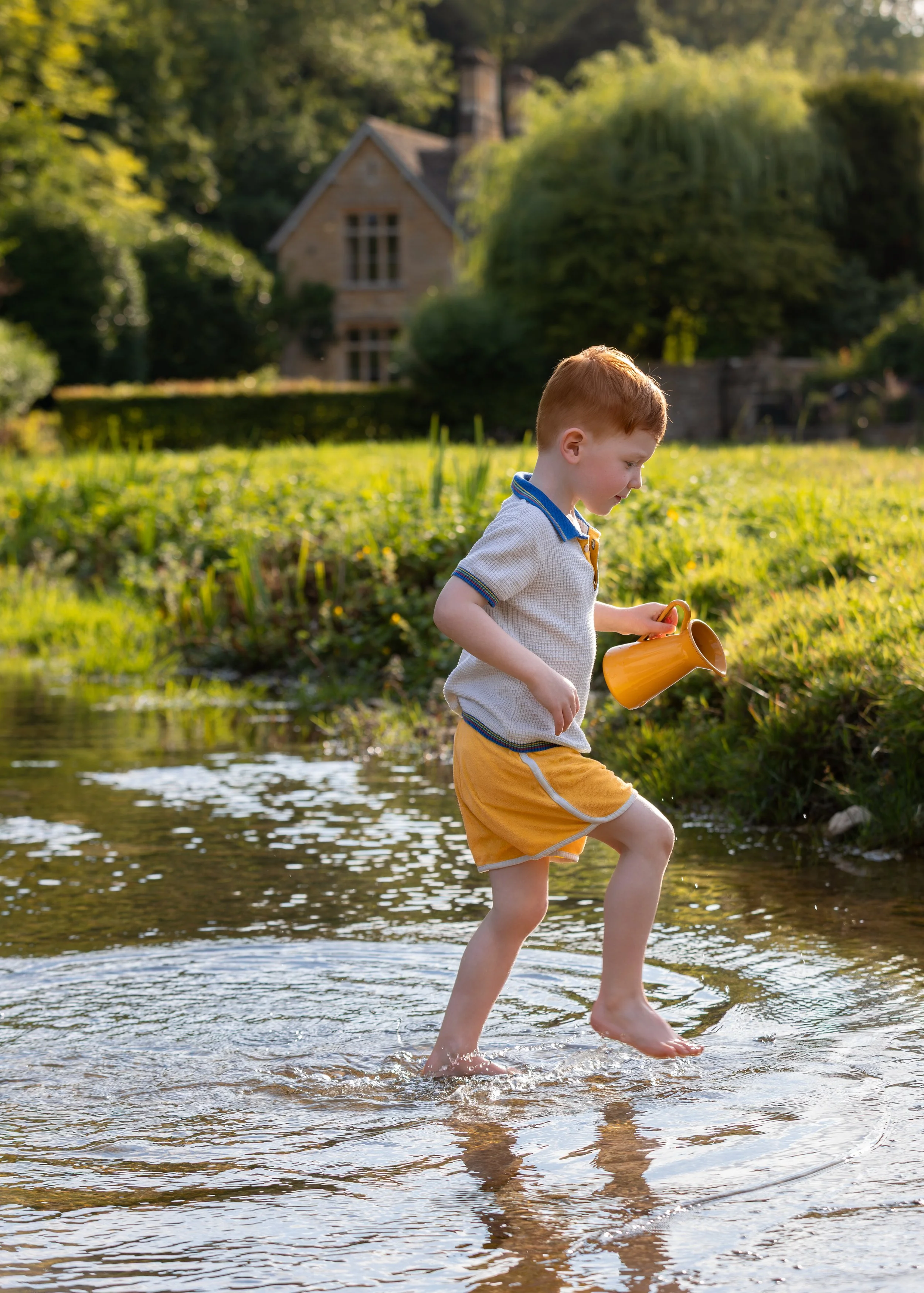 Child playing in river sunny hot day