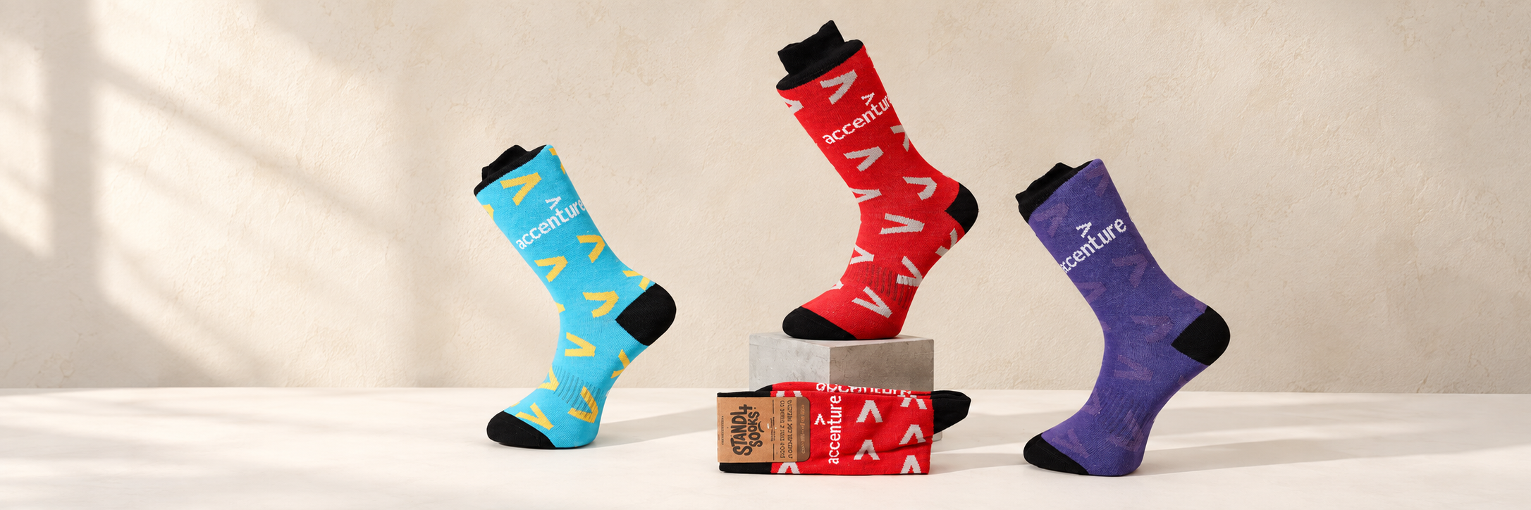 Blue, red and purple Accenture custom socks showing different branded colourways and knitted logo patterns
