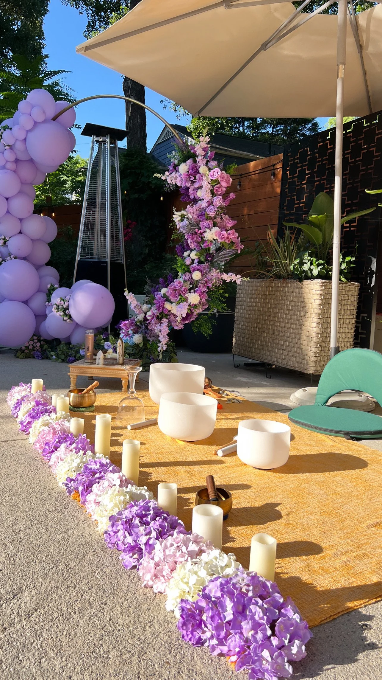 Luxury outdoor sound bath setup with crystal singing bowls, floral arch, and candles at sunset – energy healing and chakra alignment Atlanta wellness event