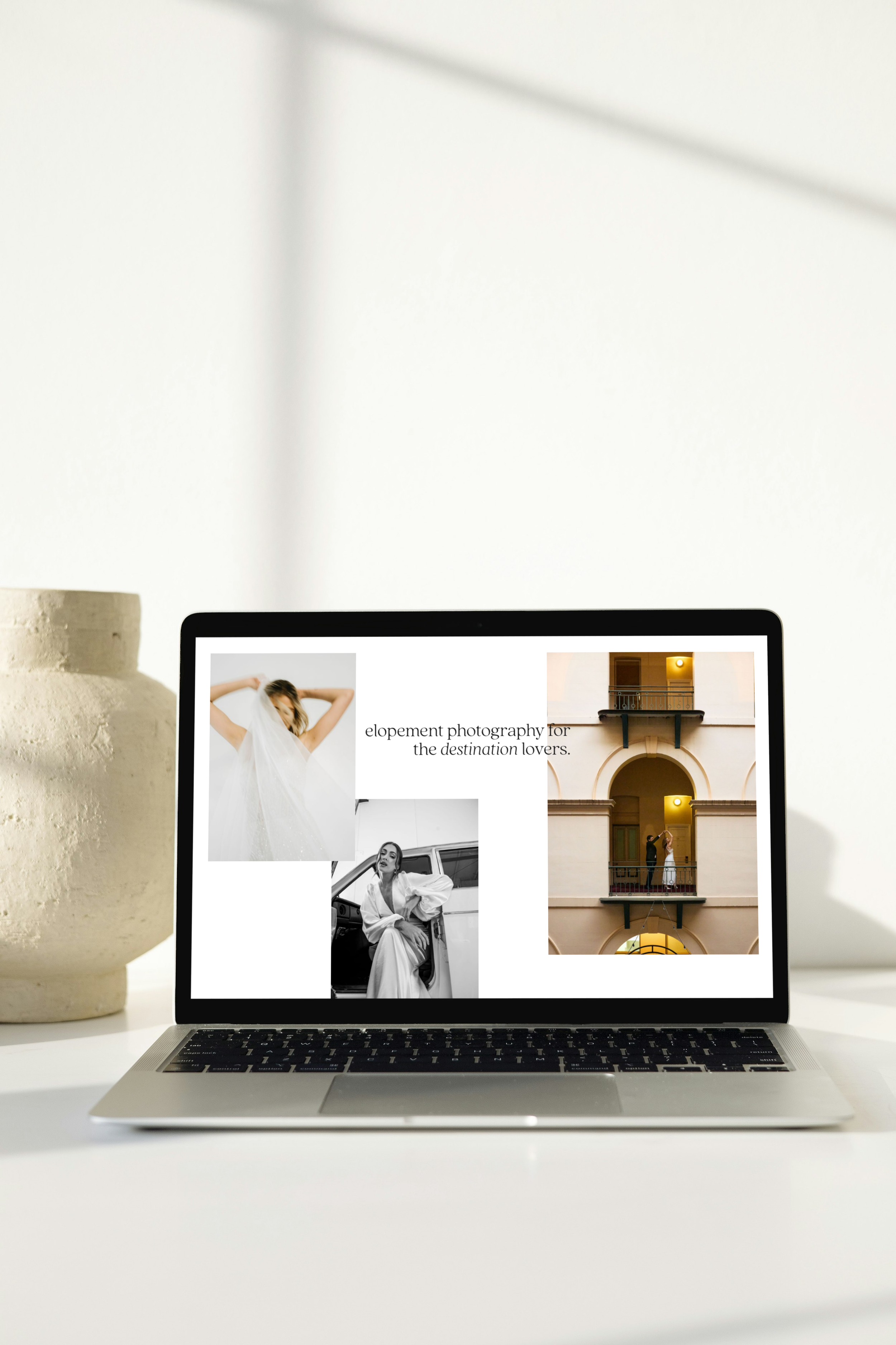 Open laptop on a white desk displaying a photography website with images of women and a building, alongside text about wedding photography for destination lovers.