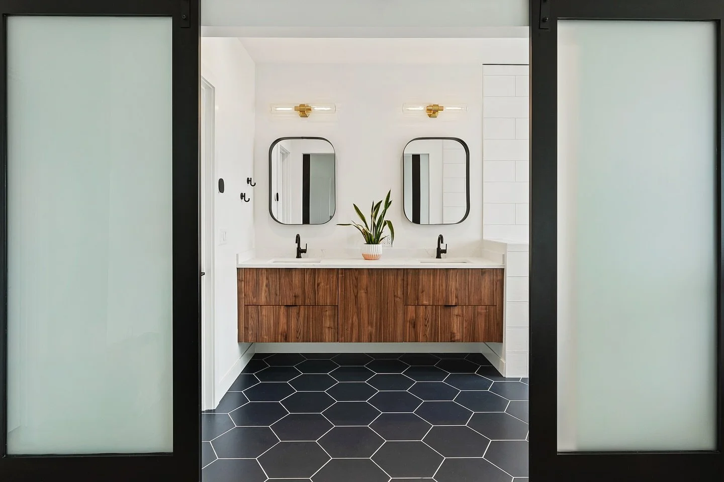 Step inside this modern bathroom, part of our #InnisArdenCliffsideModern project 

The modern bathroom layers clean lines, contrasting tones, and bold geometric tile to create a space that feels both striking and serene

Sliding barn doors with frost