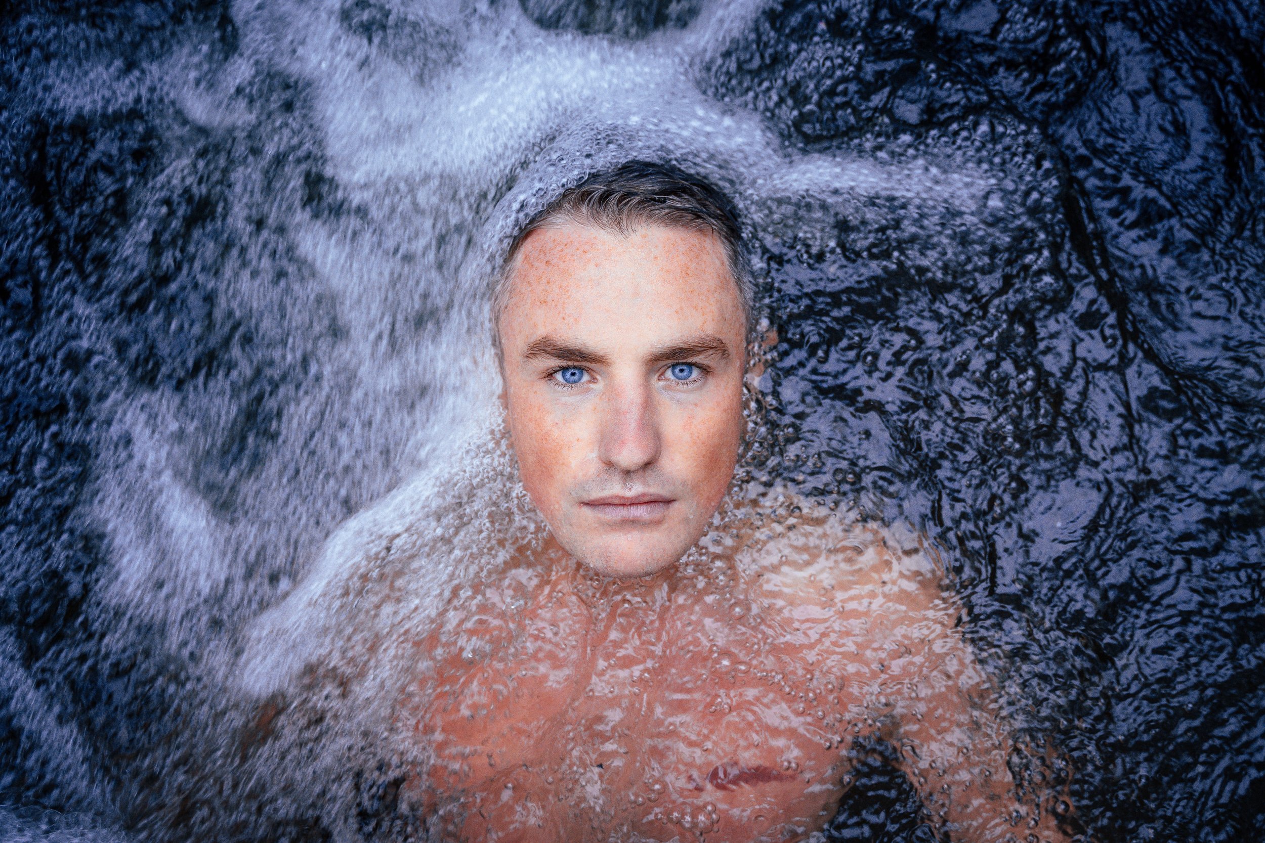 Ben Lucas in cold water beneath a waterfall