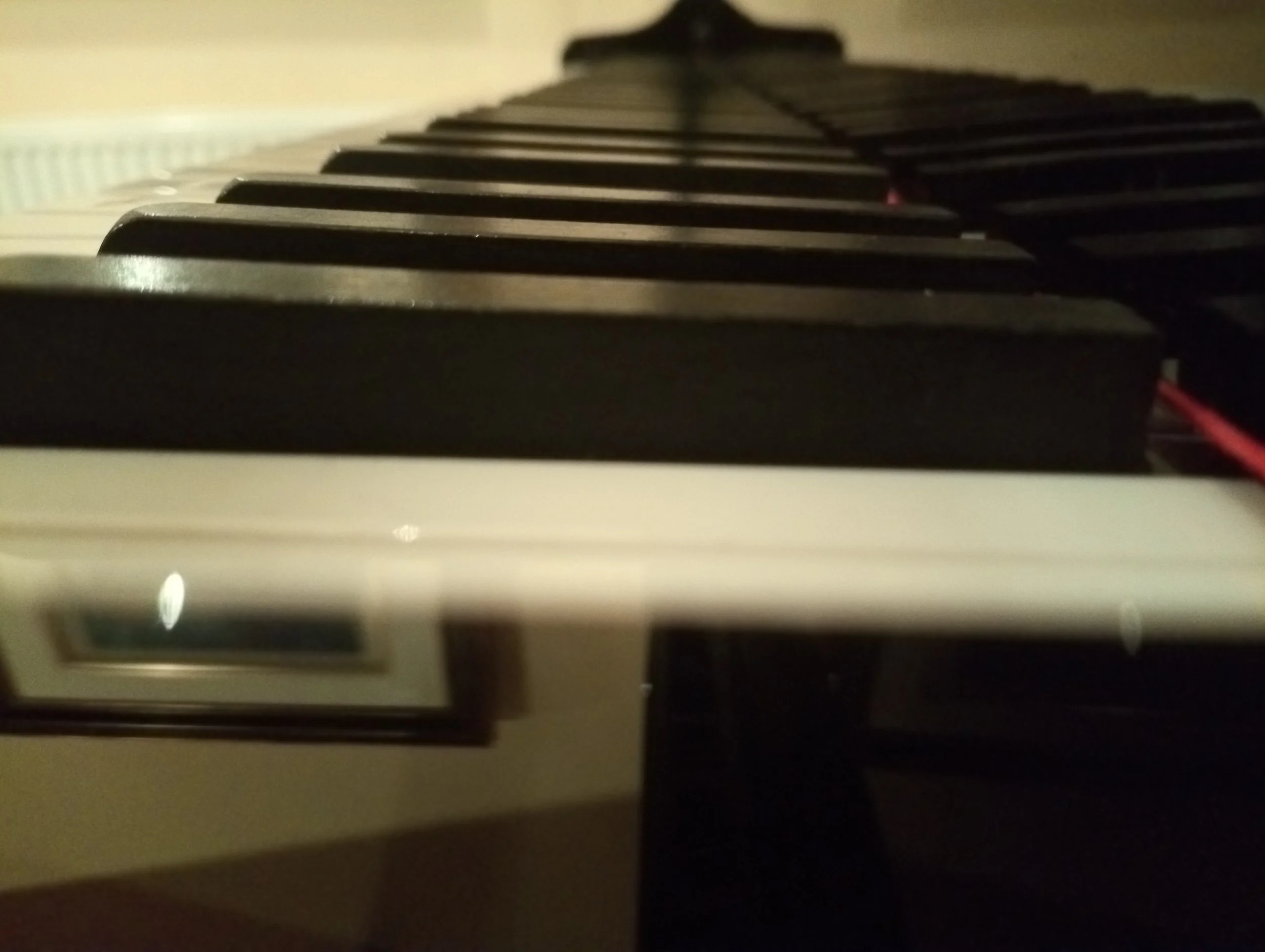 Close-up photograph of piano keys, focusing on the black keys from an angle.