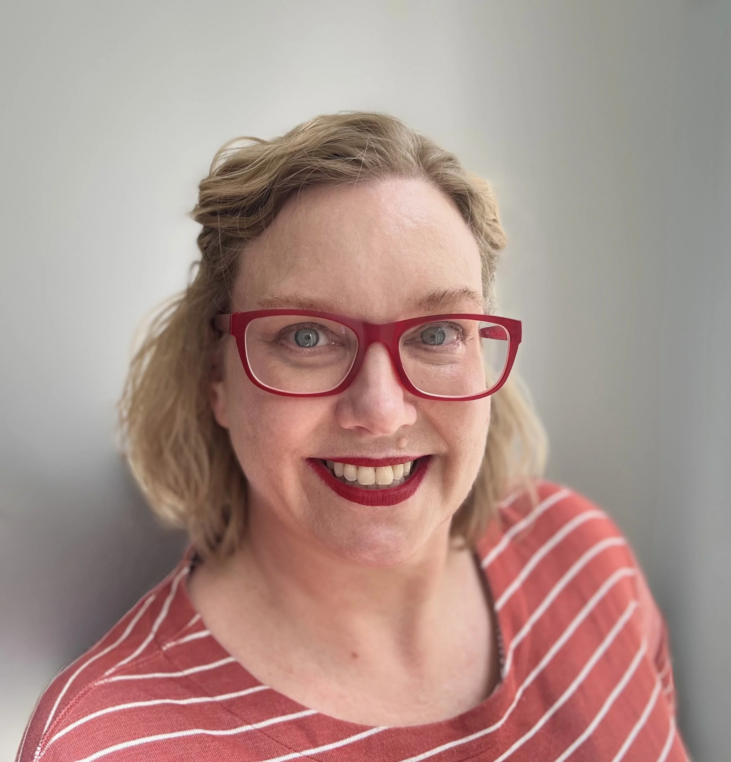 Nicole  Nurse Practitioner. Menopause Specialist. Red glasses. Red stripped shirt.