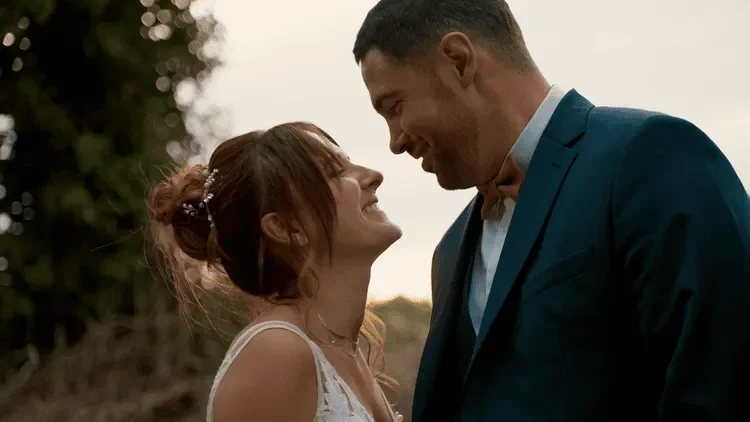 Marie-Laure et Alexandre, les mariés, qui se regardent amoureusement en rigolant pendant la séance couple de leur mariage.