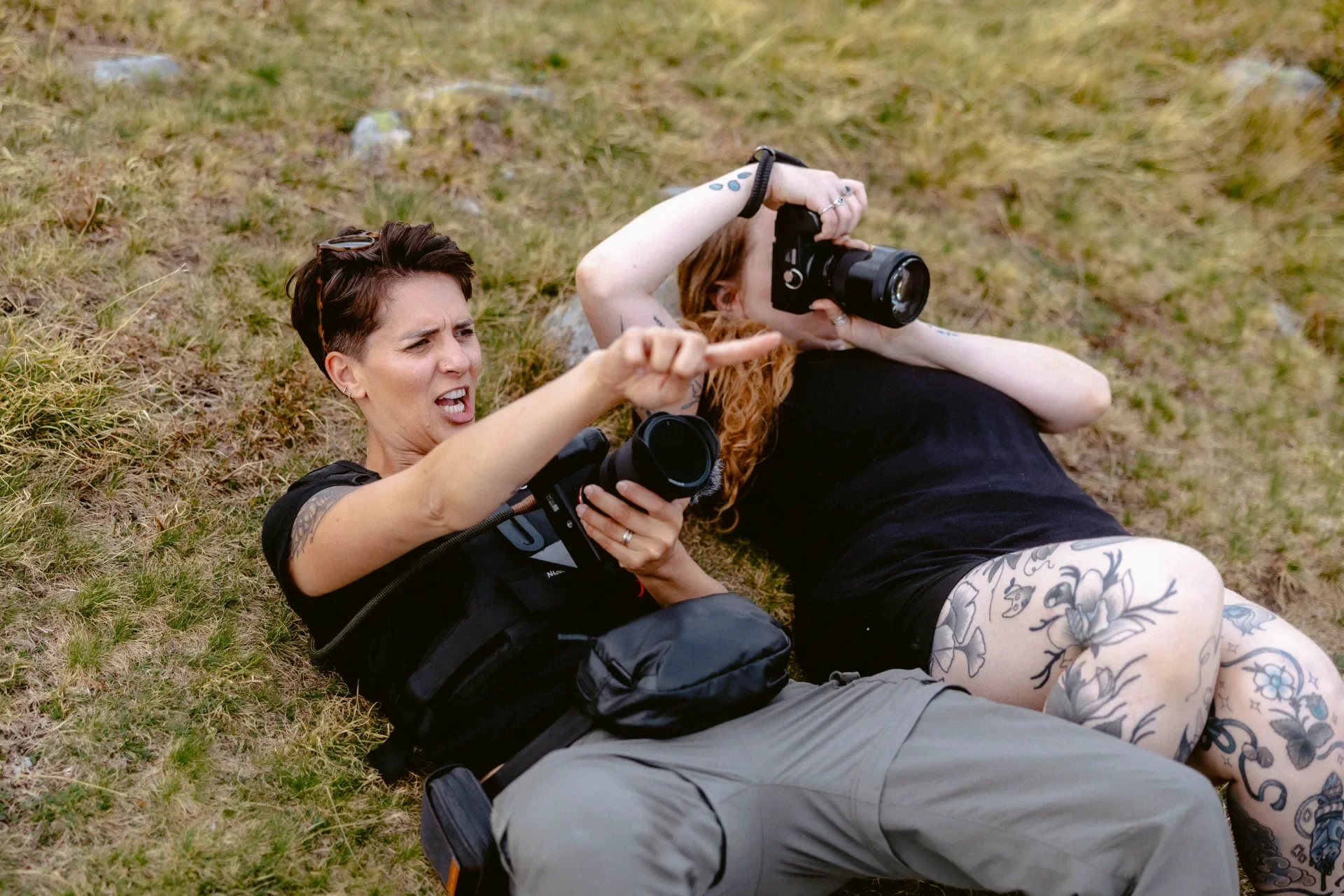 Photographe et vidéaste allongées au sol entrain de filmer et photographier.