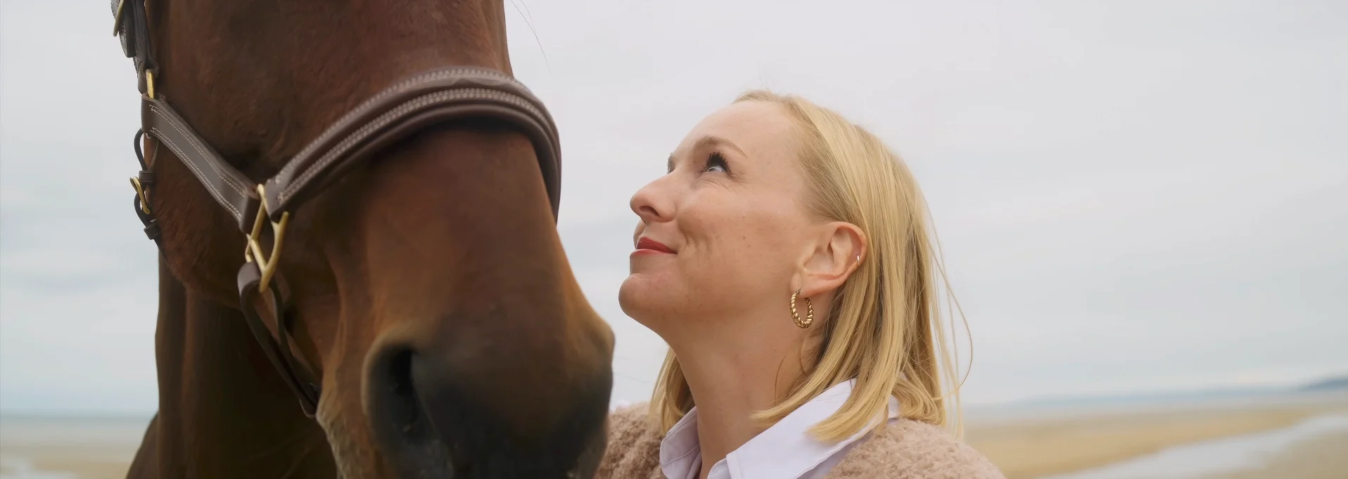 Portrait vidéo de Clémence et son cheval Euro sur la plage de Merville-Franceville. Plan rapproché de Clémence qui regarde son cheval.