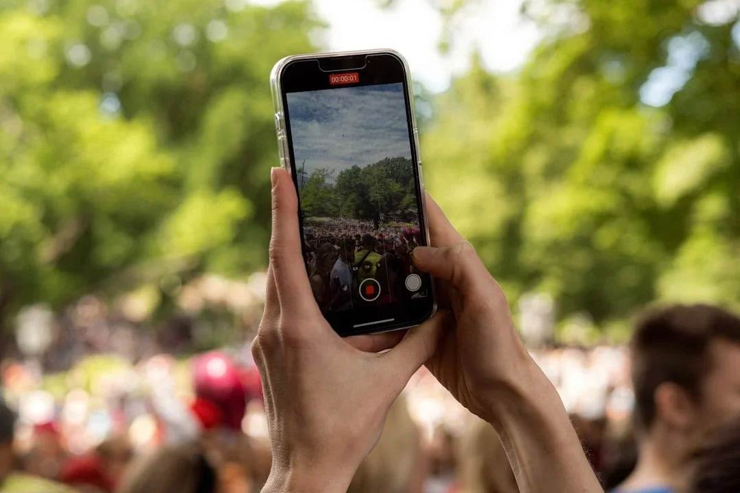 Personne entrain de filmer un événement avec son smarphone.