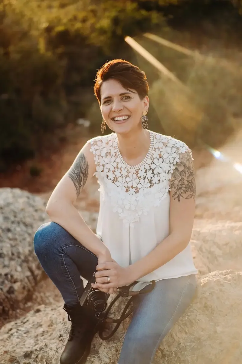 Portrait de Charlotte GANDON, vidéaste de mariage en Savoie assise sur un rocher.