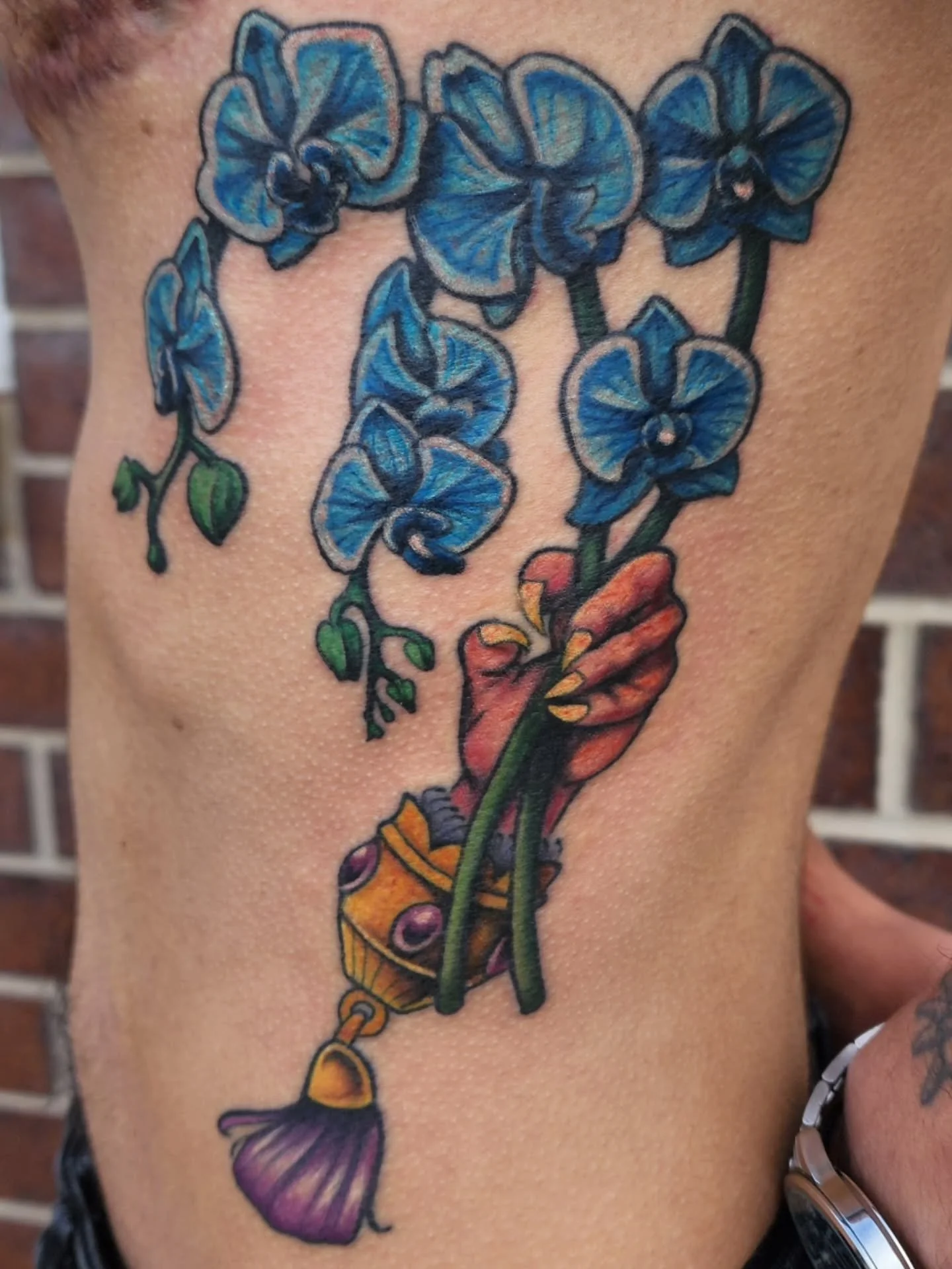 Opossum hand holding some orchids. 
I wish I could keep my orchids alive 🫠 I'm also a bit behind on emails and messages. I will be trying to get back to everyone later today and tomorrow