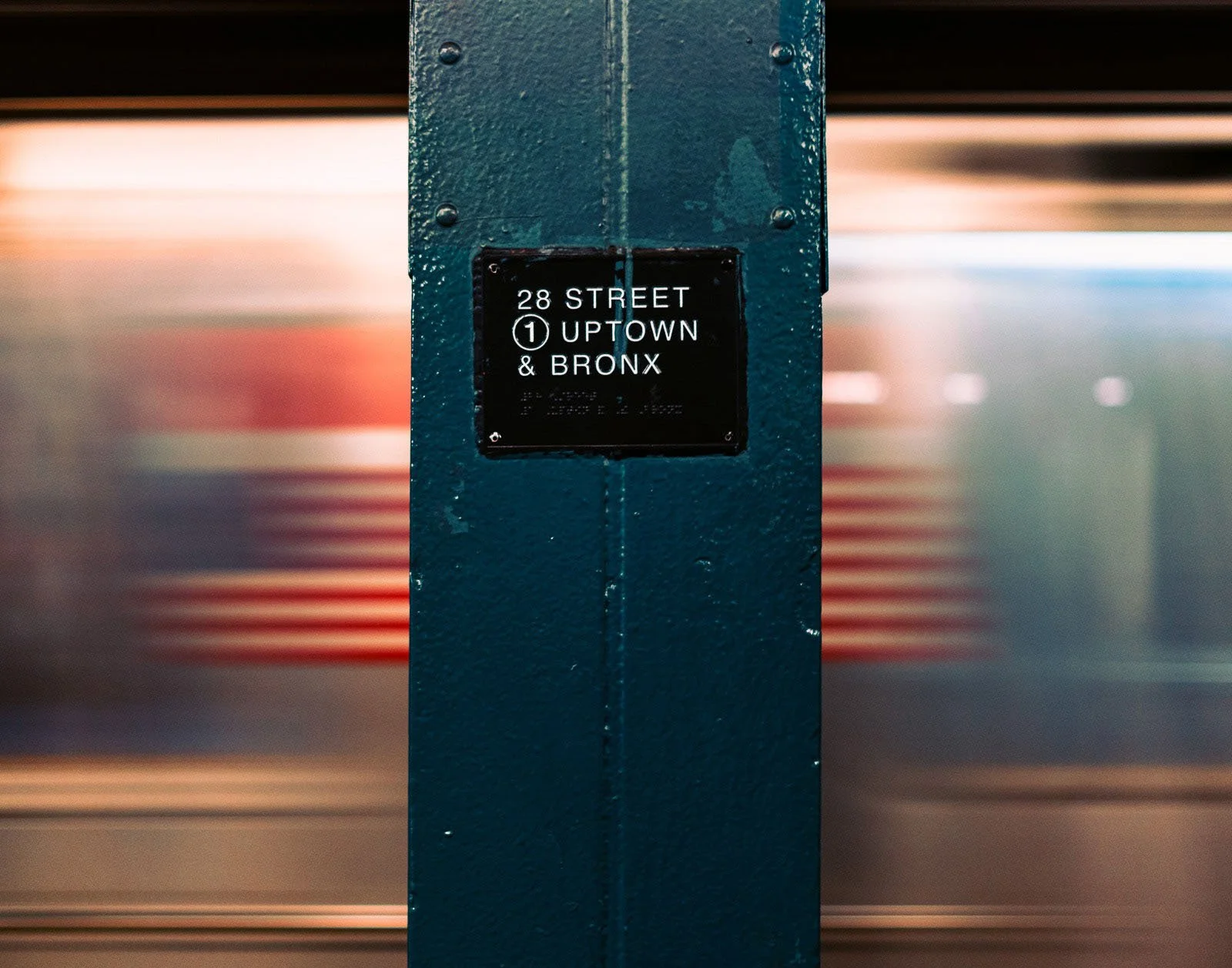 This print captures the 28th Street Station with a blurred train car rushing by in the background. The American flag on the train car adds a patriotic touch to the scene.