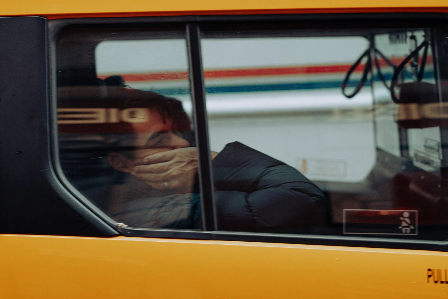 Passenger covering his face in the back of a yellow taxi