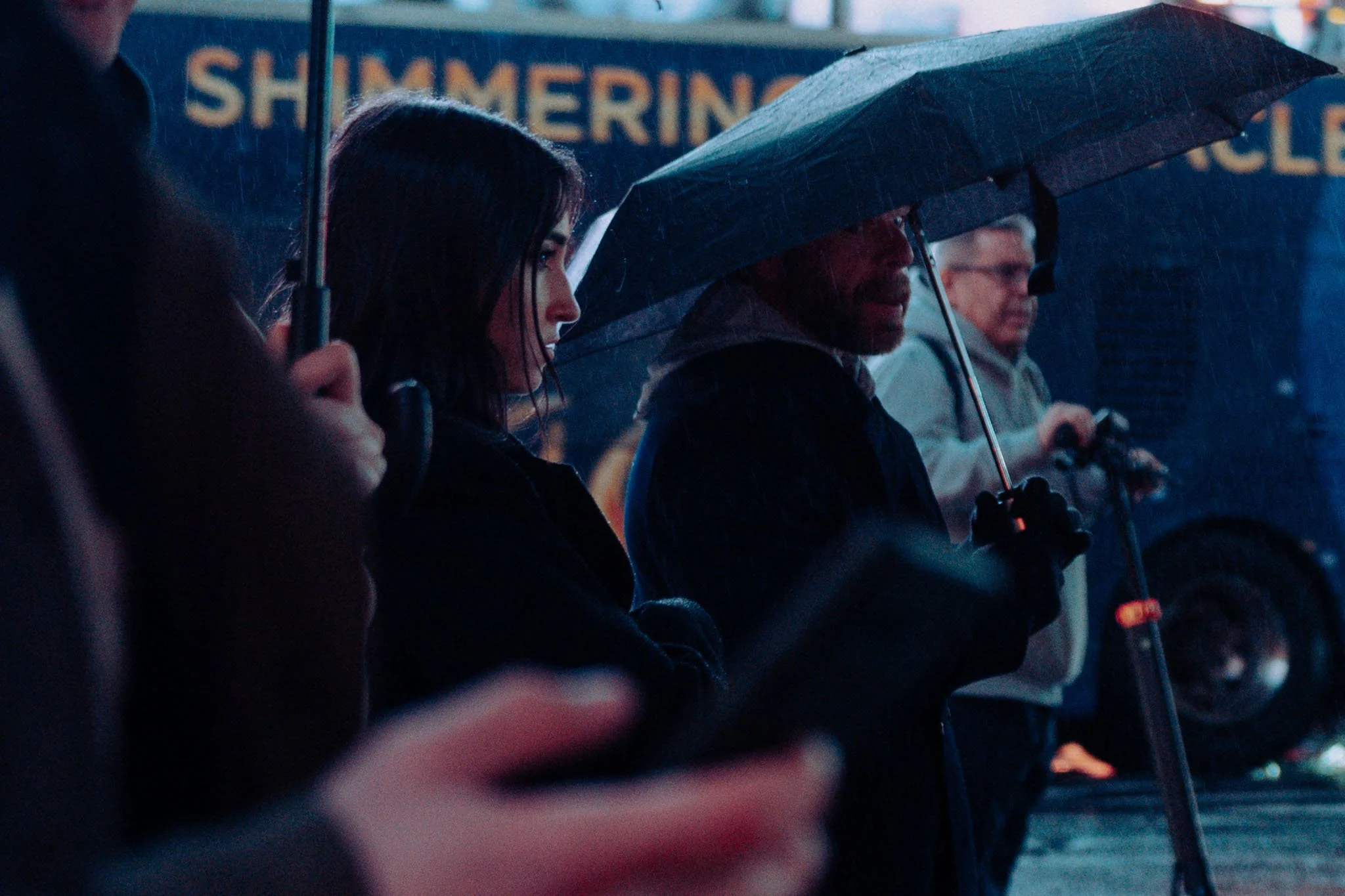 A woman waits to cross the street in New York as rain pours down on her
