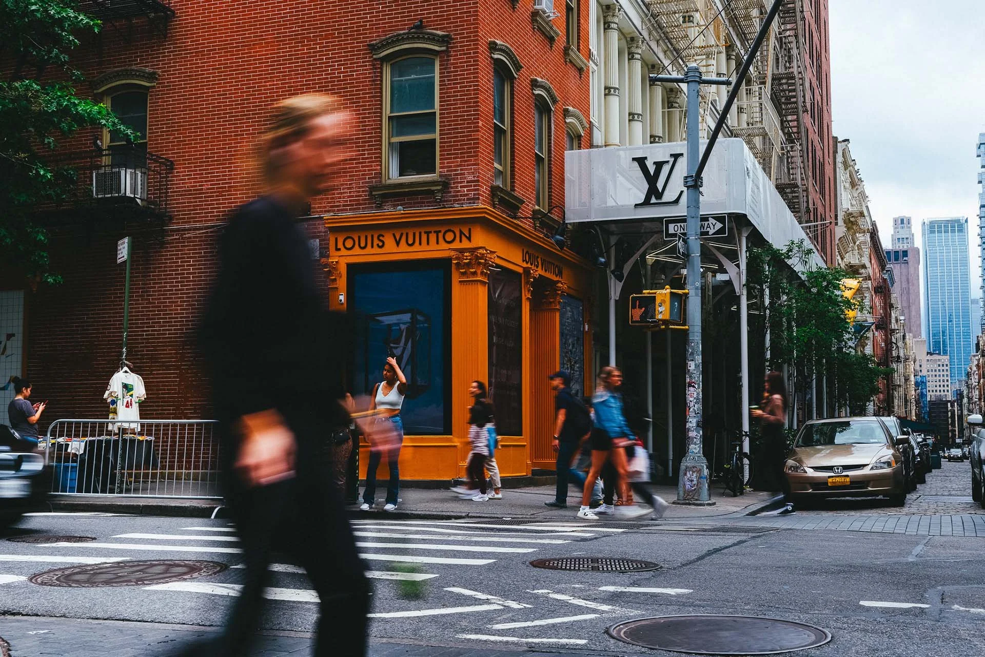 This photo print captures the chaotic energy of a New York City street. A blurred figure hurries past on the left side, contrasting with the sharp focus of a woman in the background, who seems to be in a state of confusion.