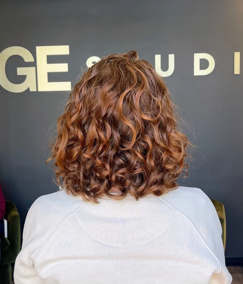 Obsessed with how this one came together 🧡

Master stylist Krista created the perfect curly cut and color combo here&mdash;shaping the curls to enhance their natural movement while adding that warm, dimensional tone to make everything pop. Soft, bou